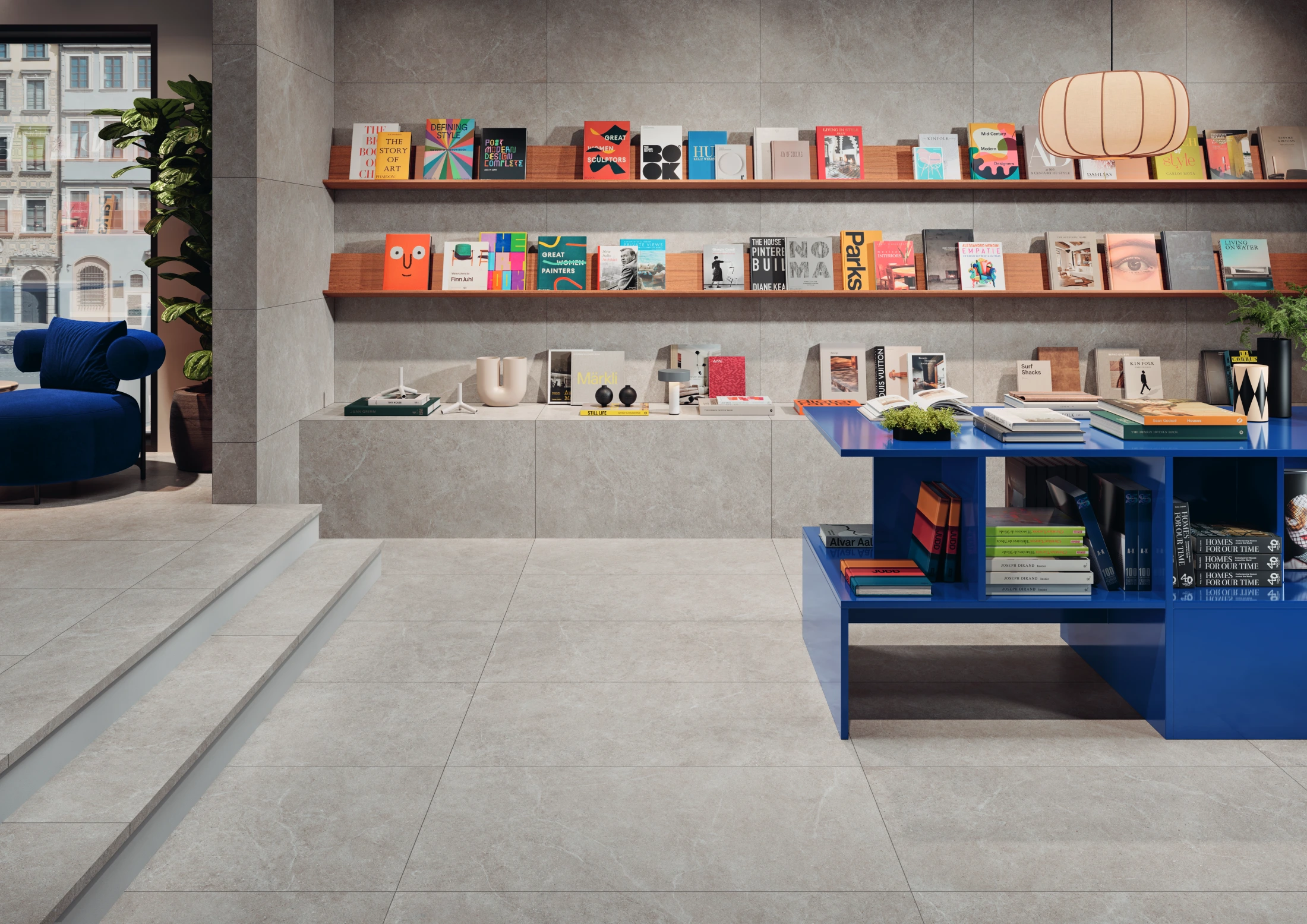 Modern bookstore interior with blue chair, bookshelves, and a blue table with books and plants.