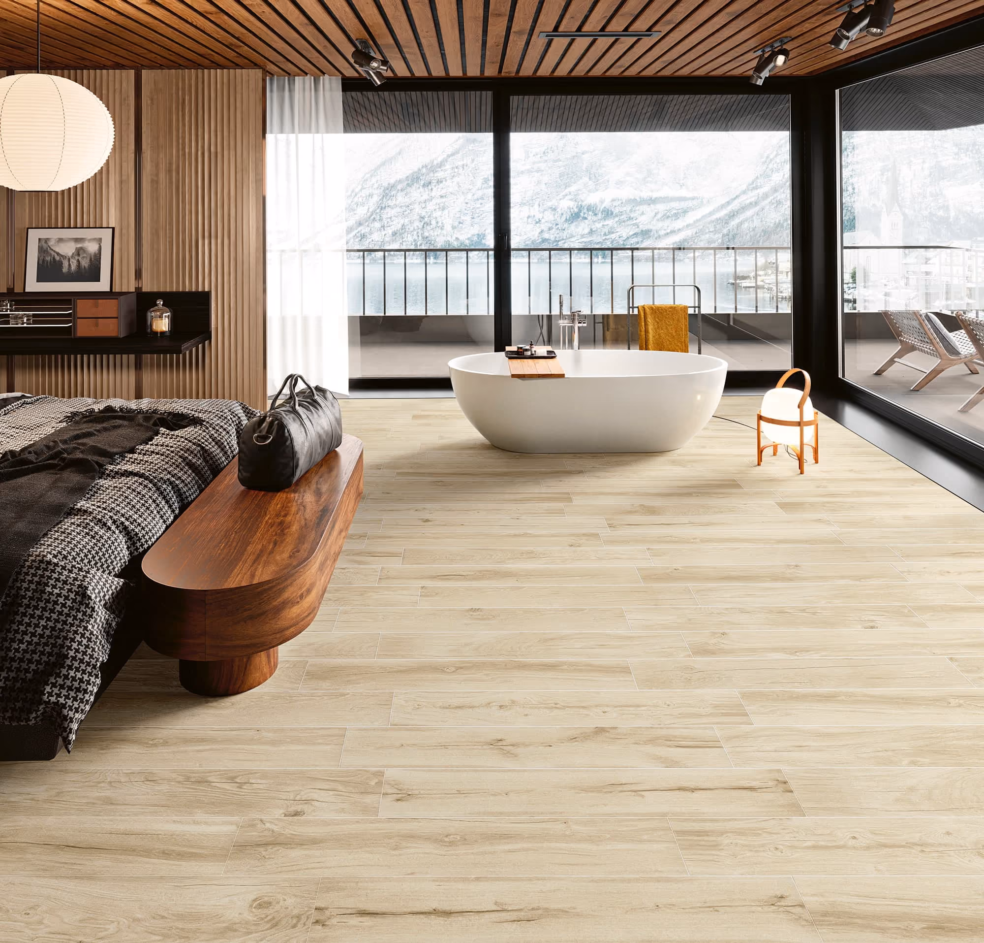 Modern bedroom with wooden bench, bed, freestanding bathtub, and large windows overlooking snowy mountains.