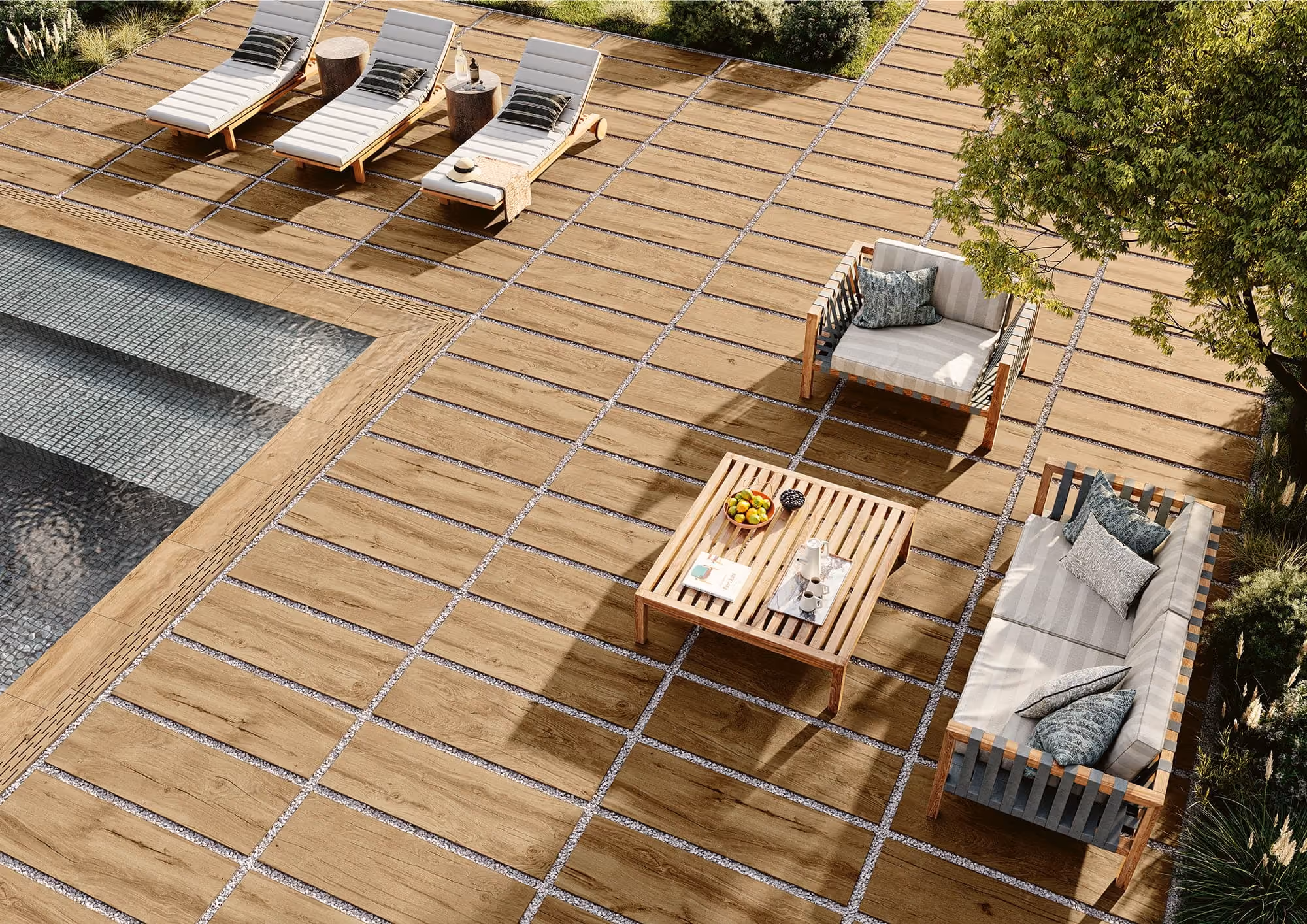 Outdoor patio with wooden tile flooring, lounge chairs, cushioned sofa, armchair, and a wooden coffee table.