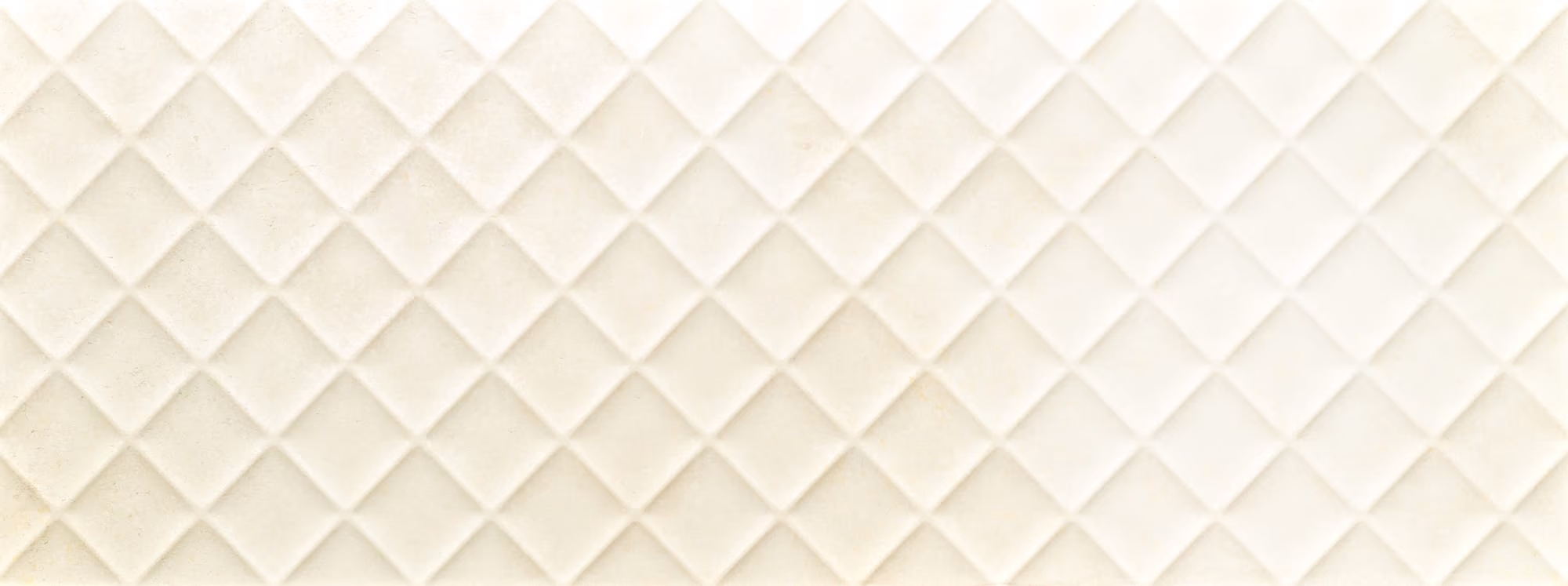 Pattern of beige diamond-shaped quilted tiles arranged in rows forming a textured surface.