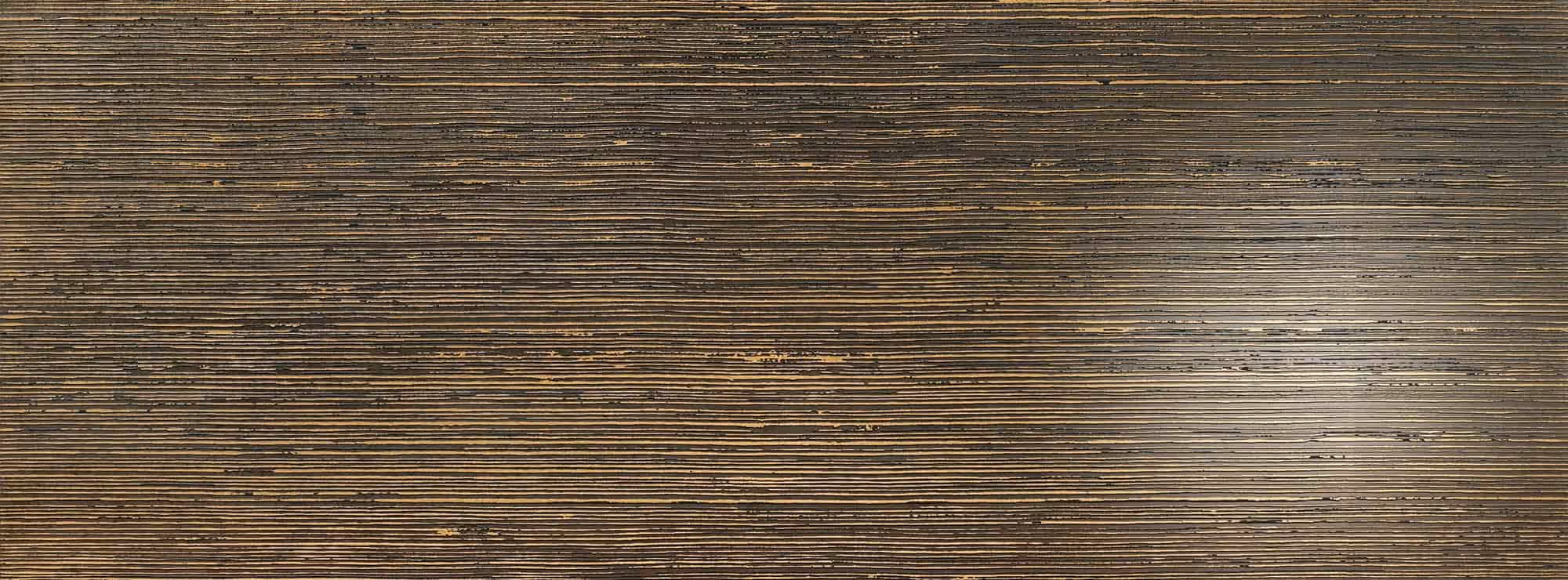 Close-up of dark metallic surface with fine horizontal grooves and worn texture.