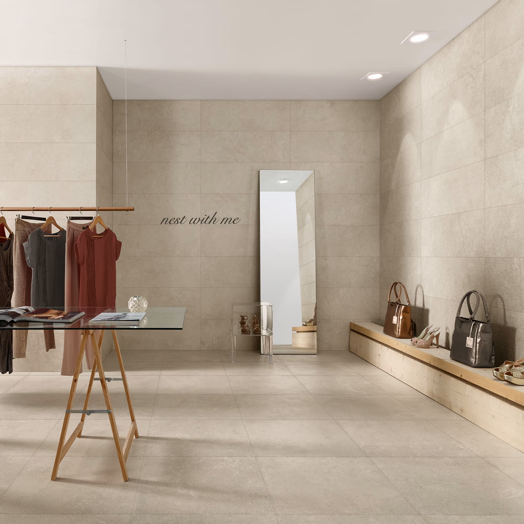 Minimalist boutique with neutral walls, clothes rack, glass table, mirror, handbags, and shoes on bench.