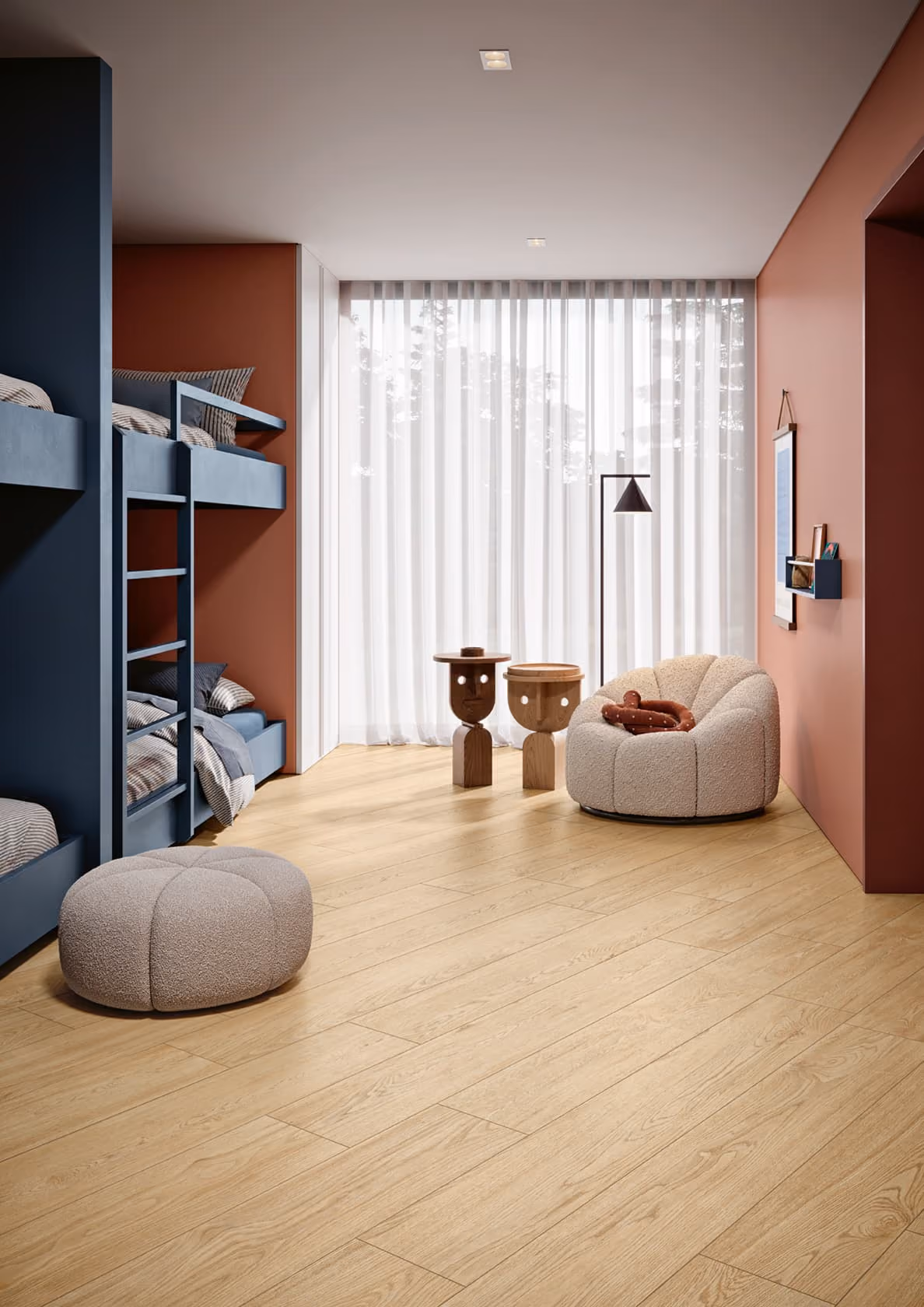 Modern room with blue bunk beds, beige cushioned chair and ottoman, wooden floor, and sheer curtains.