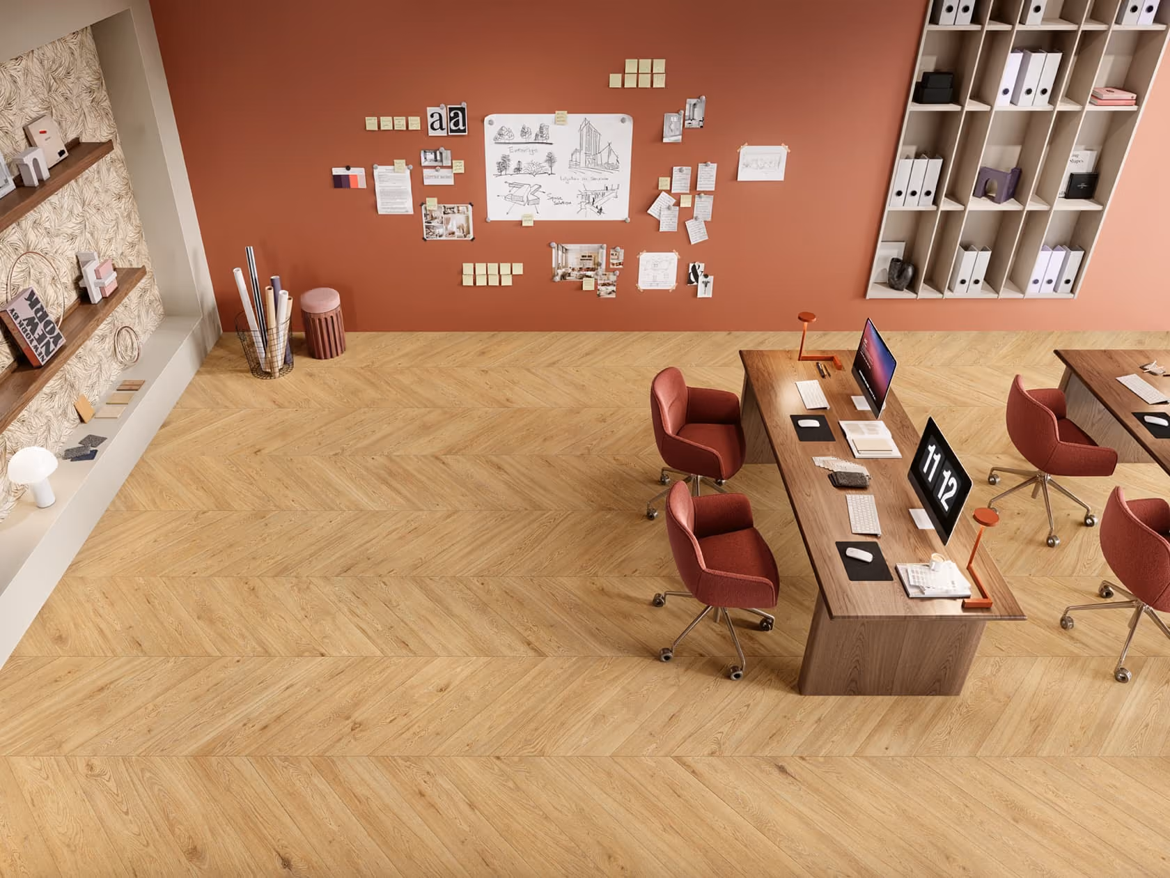 Top-down view of modern office with wooden floors, desks, red chairs, and a wall with pinned notes.