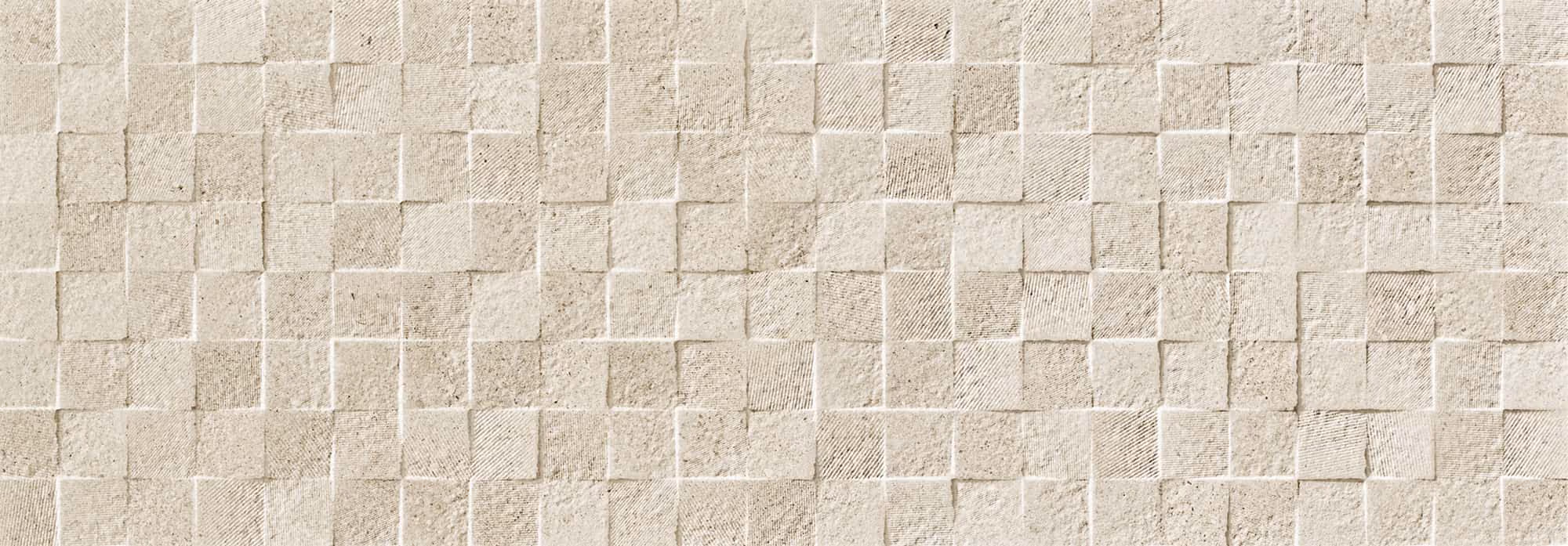 Close-up of rough textured beige stone tiles arranged in a grid pattern on a wall.