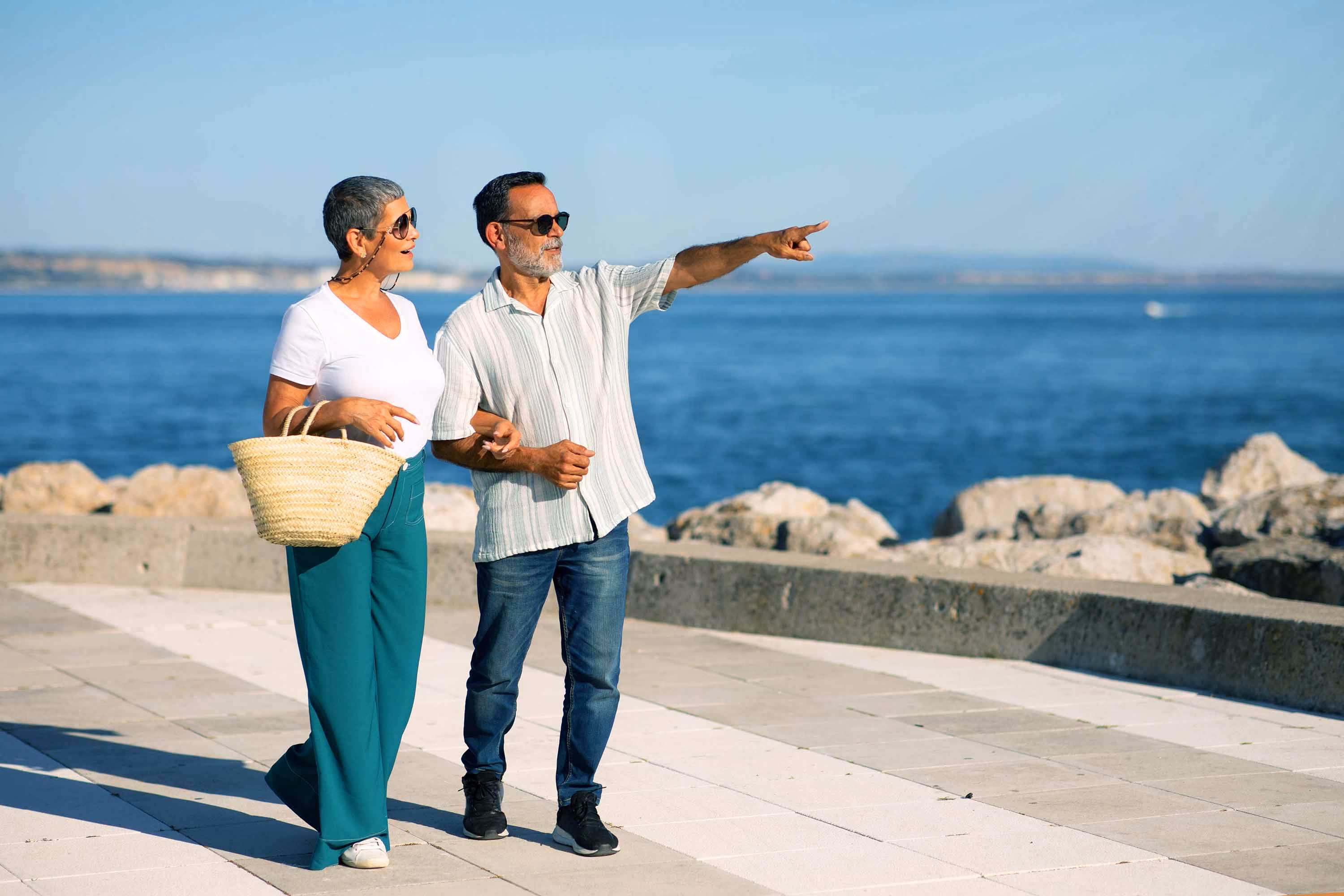 Elderly couple exploring Portugal, ocean in the background
