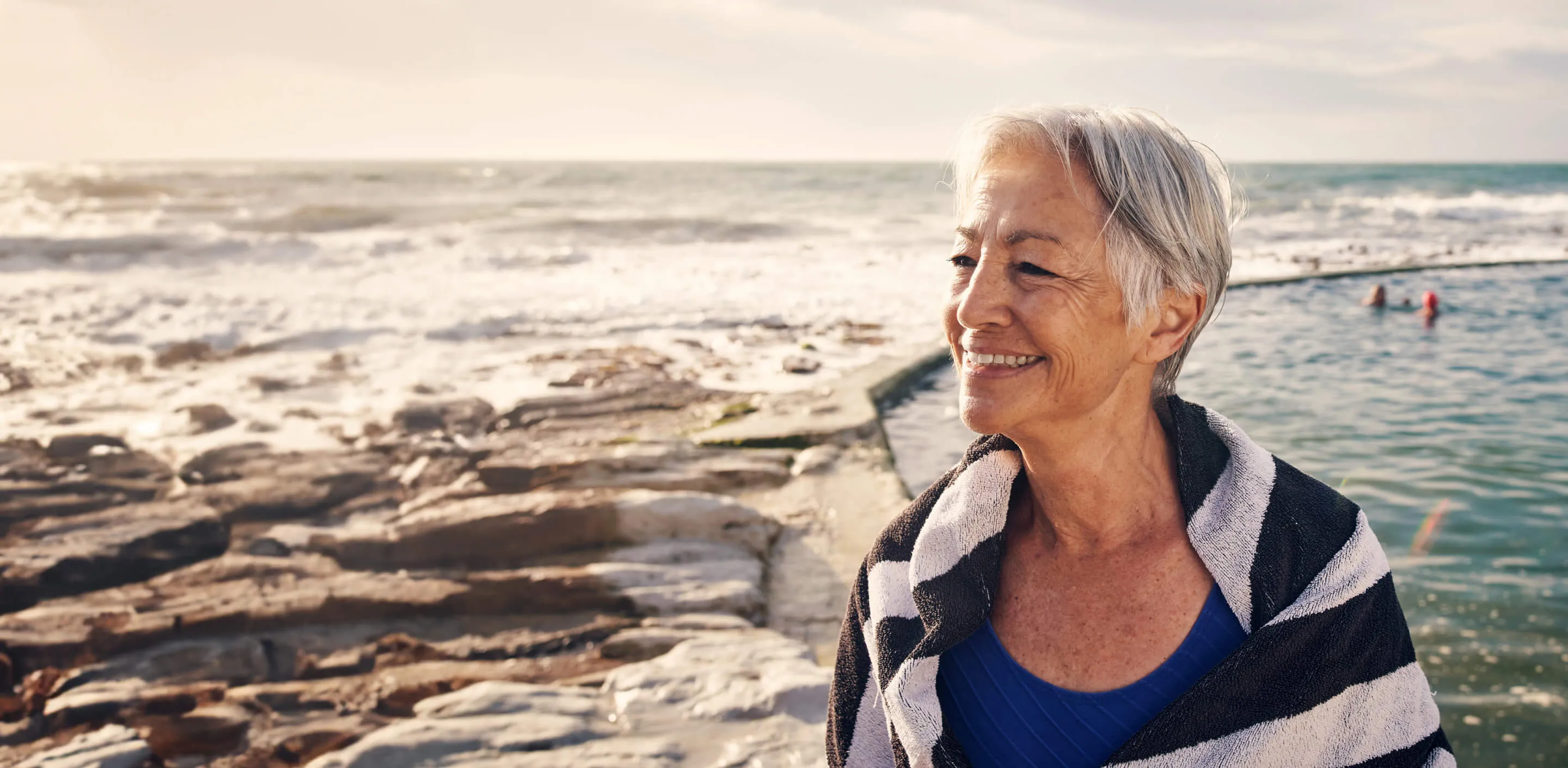 A woman standing on a beach next to the ocean.