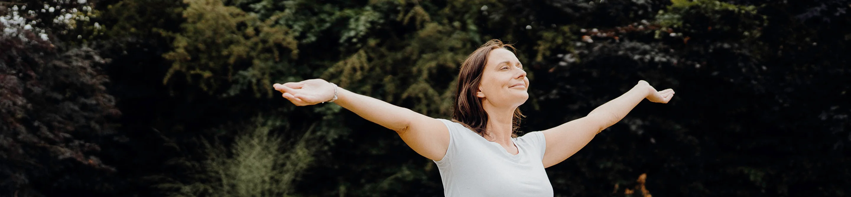 Woman standing with arms outstretched, representing relief and freedom from chronic symptoms