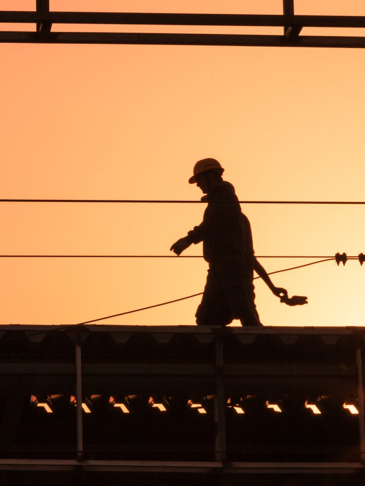 Anställd går på spåret i solnedgång