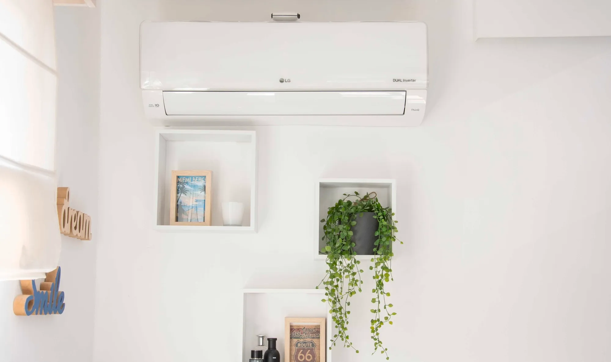 Witte LG Dual Inverter airco van Energy Protect in modern interieur met wandplanken en hangplant.