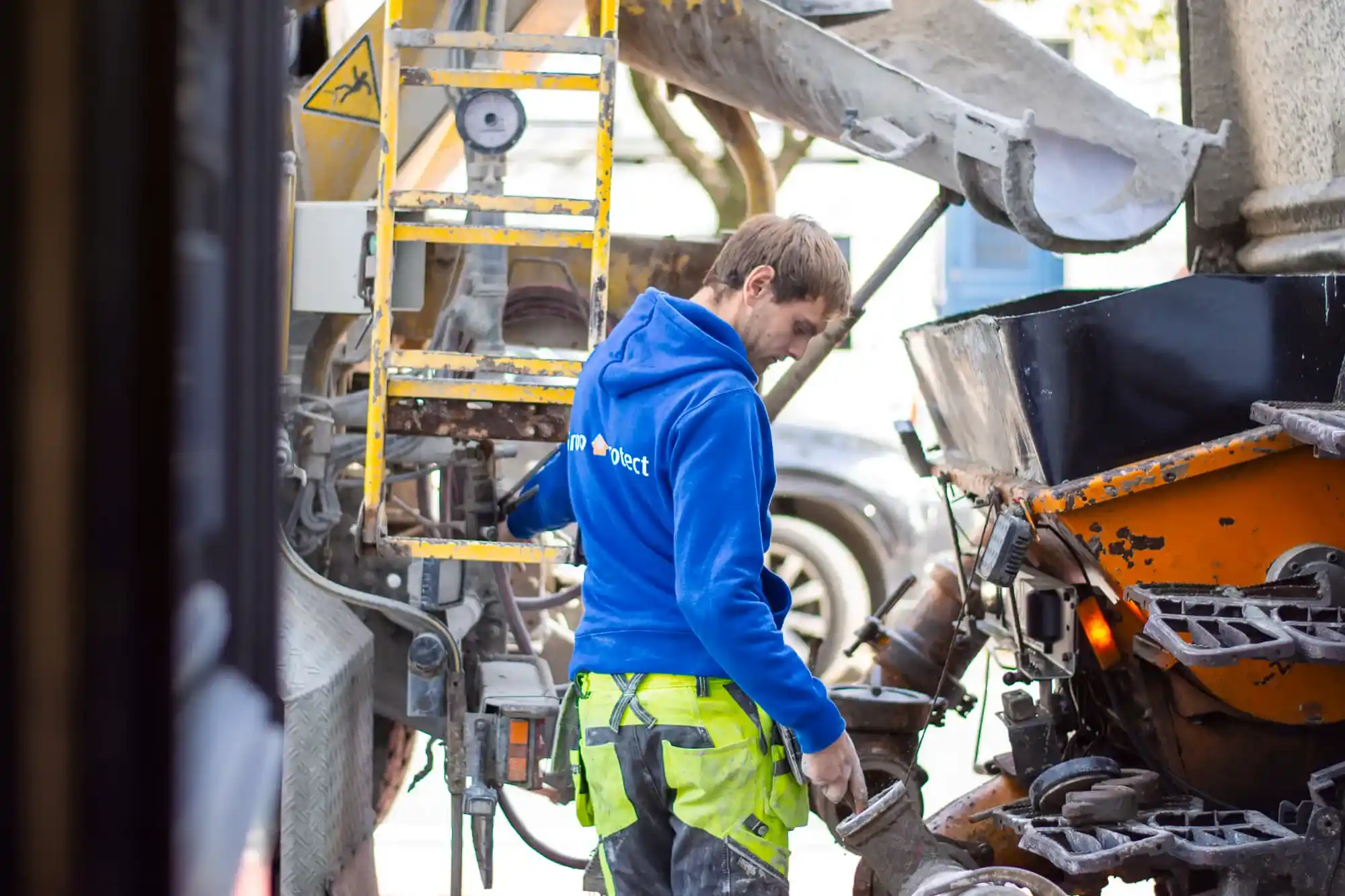 Vakman bedient een mortelpomp op een aanhangwagen tijdens kelder- en dekvloerwerken