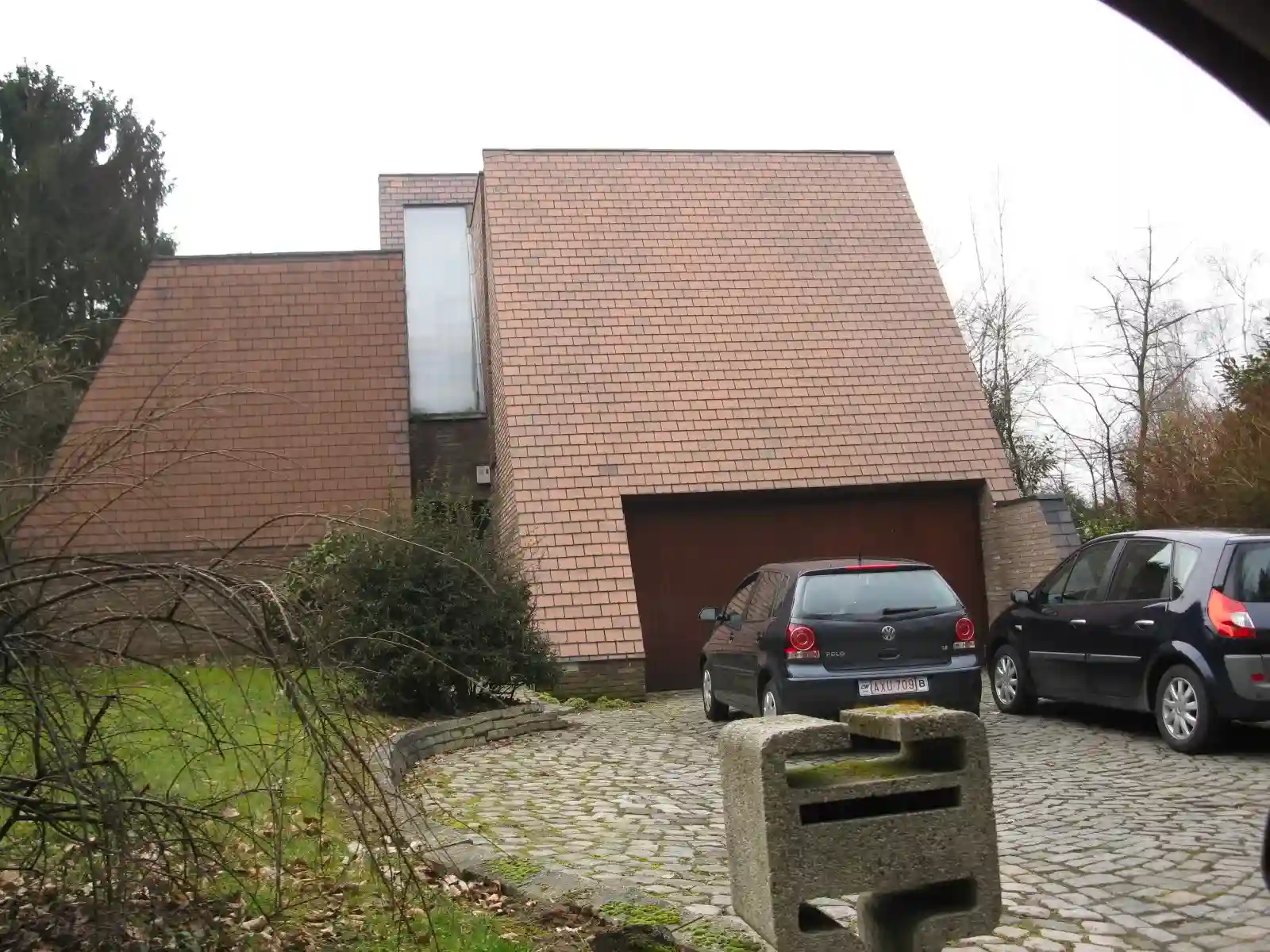 Woning met steil pannendak en bakstenen gevel, met een garage en oprit