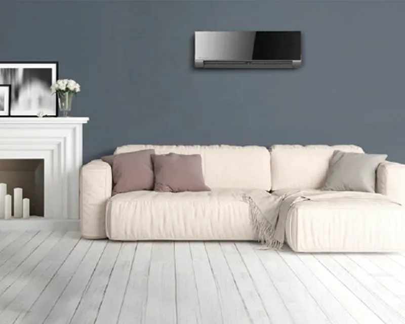 Zwarte binnenunit van een airco boven een beige hoekzetel in een woonkamer