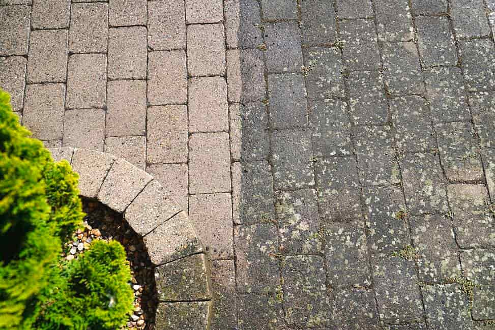 Terras met klinkers, helft proper en helft met mos en algen, voor en na terrasreiniging