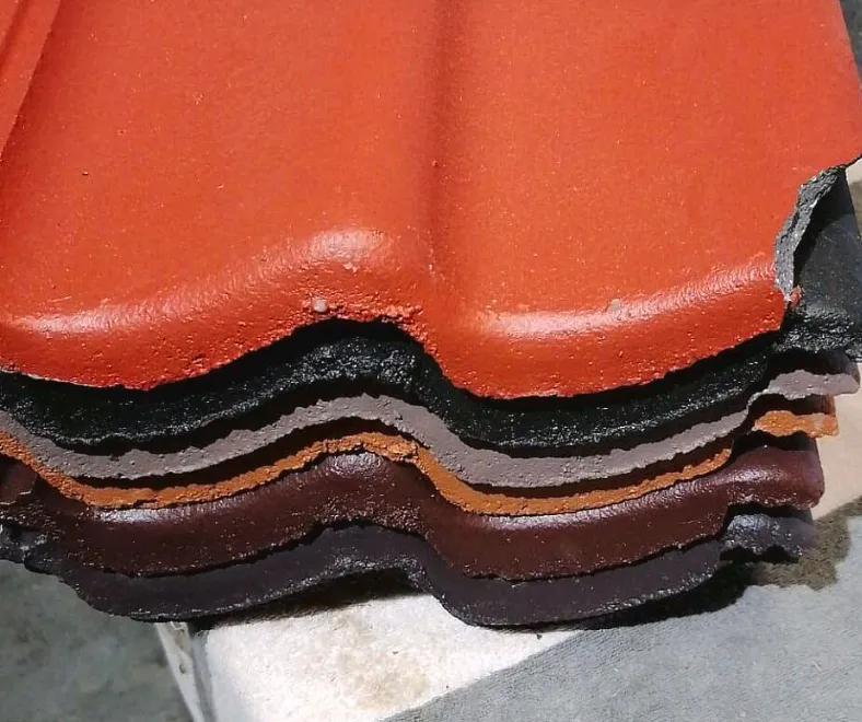 Stapel dakpannen in verschillende kleuren: rood, zwart, bruin en terracotta