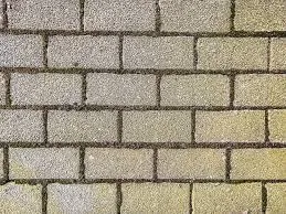 Close-up van een grijze betonklinker- of tegelvloer met een waterafstotende behandeling