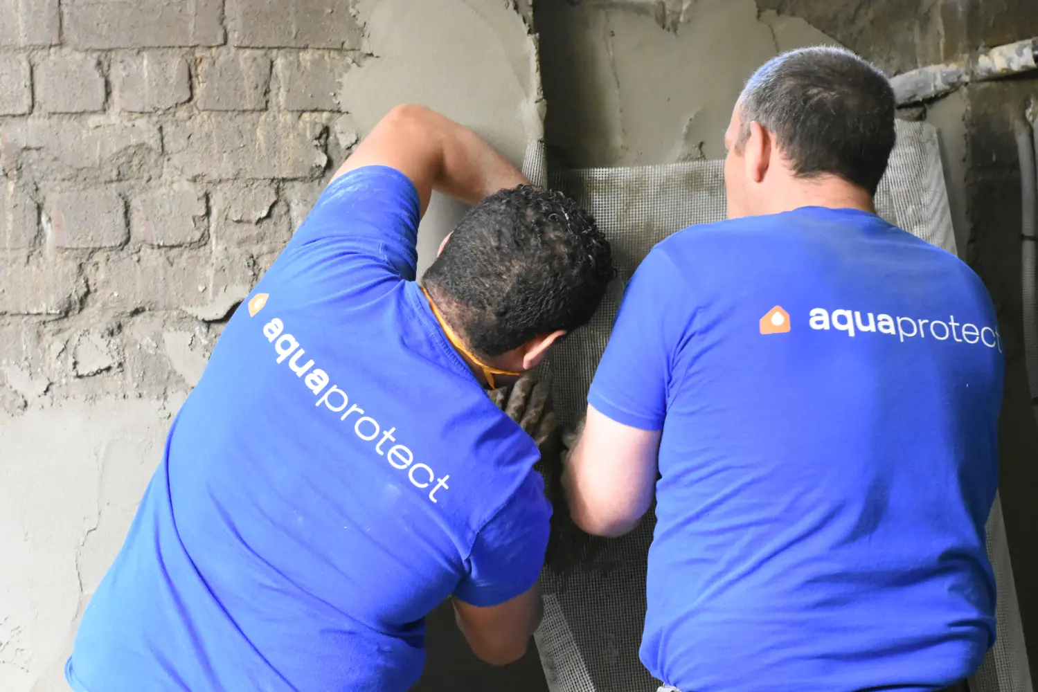 Twee vakmannen van Aqua Protect dichten een kimnaad in een kelder af