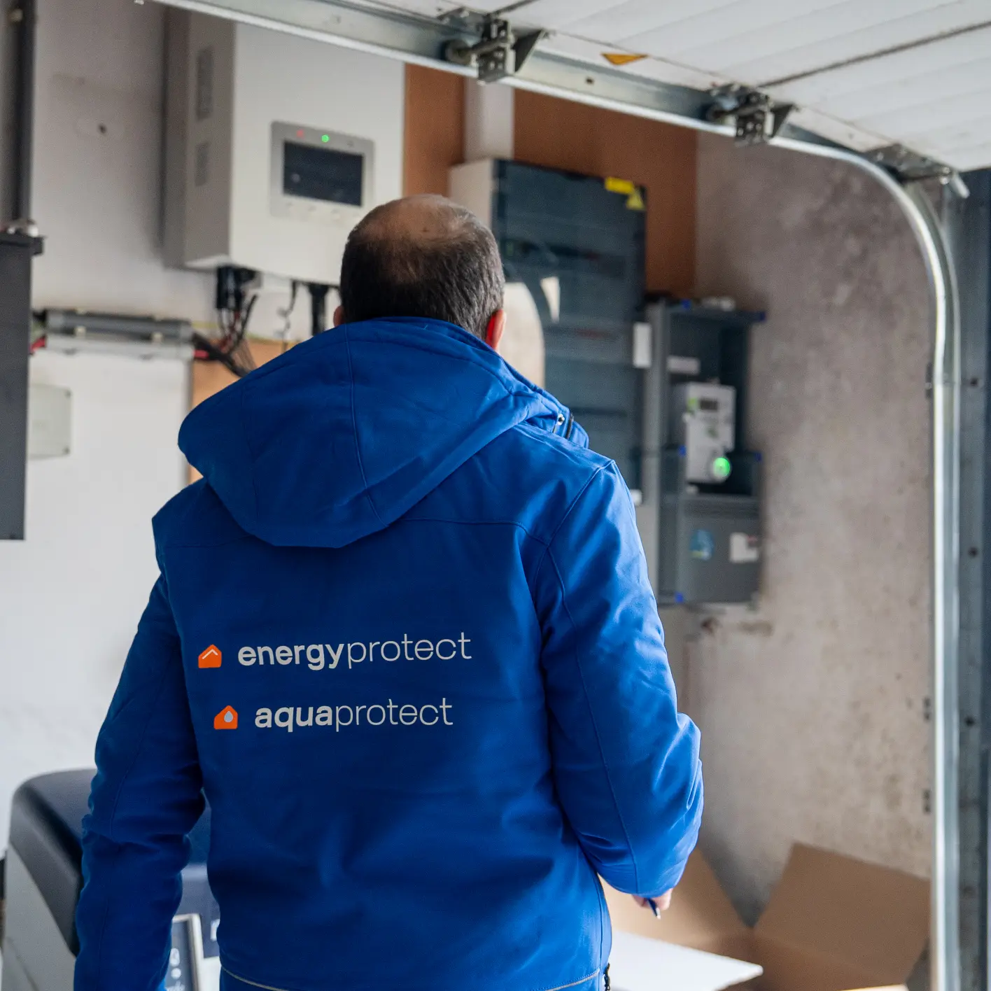 Monteur van Energy Protect bij een omvormer en thuisbatterij in een garage