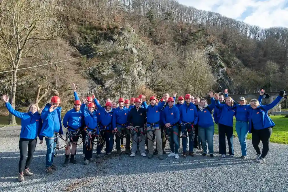 Groepsfoto van het Group Protect-team met helmen en klimuitrusting op een teamdag