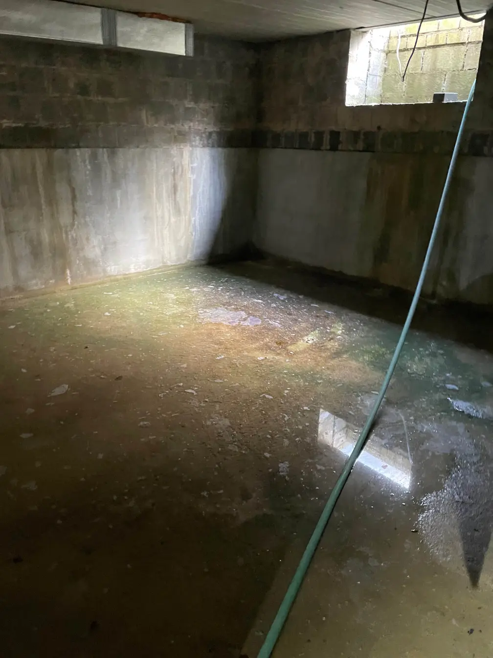 Cave aux murs en béton et au sol mouillé couvert de flaques