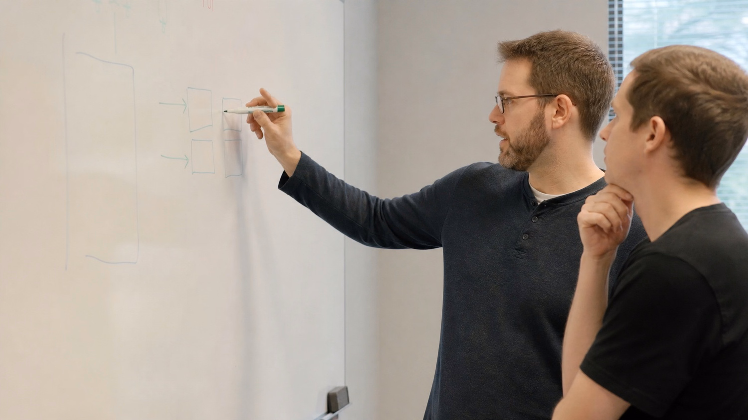 WHITEBOARD SESSION An IT professional one or two people standing at a whiteb