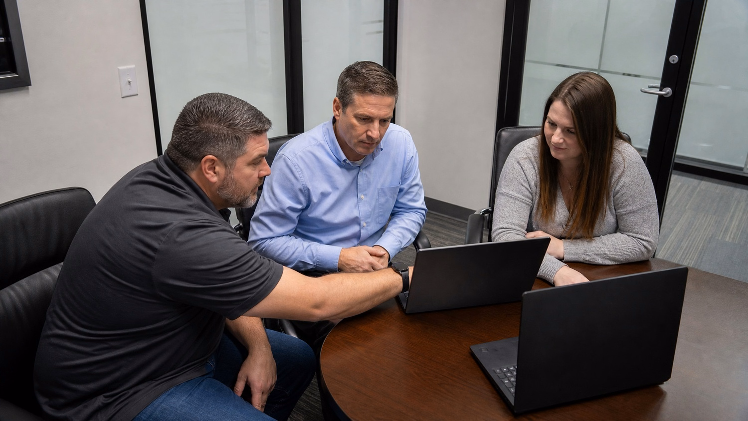 SMALL CONFERENCE ROOM An IT professional  three people seated around a small