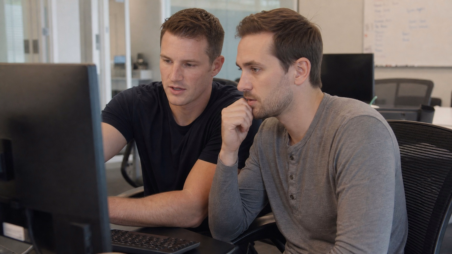SIDE-BY-SIDE PAIR An IT professional two people seated side by side reviewin
