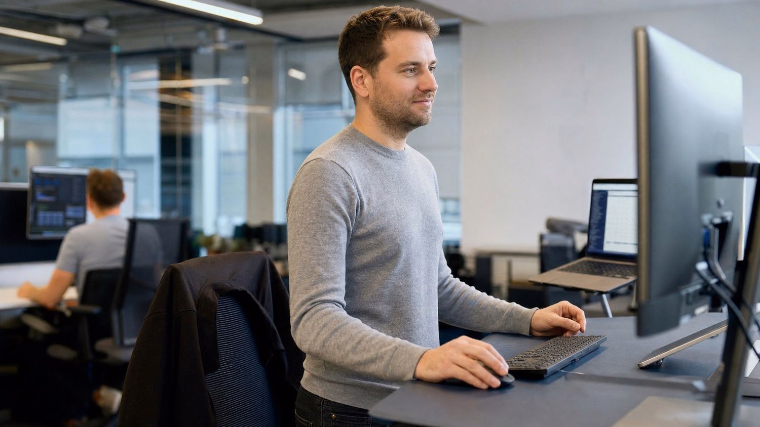 Security analyst at standing desk reviews monitor data