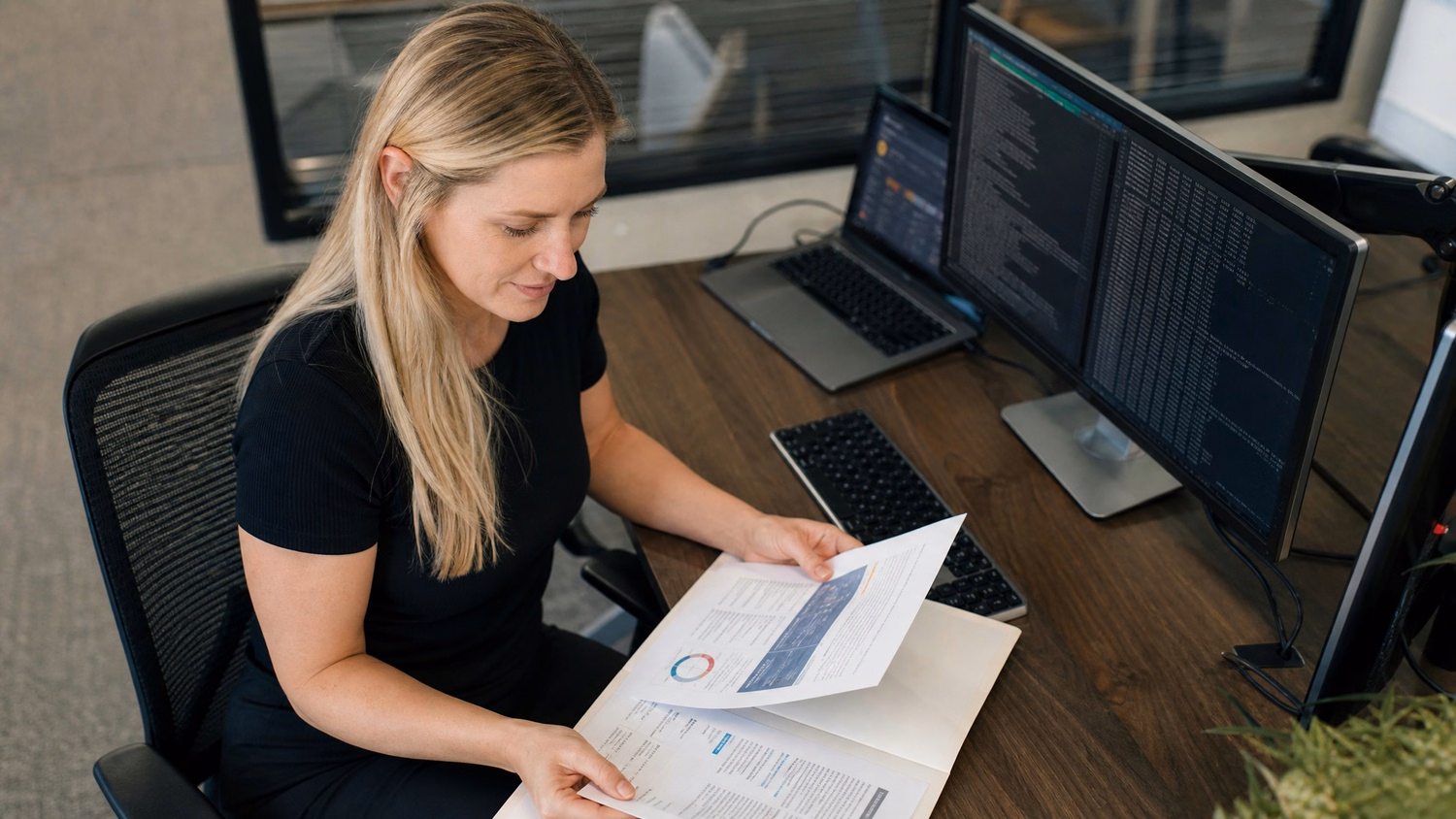 Cybersecurity analyst reviewing threat assessment report at desk 71