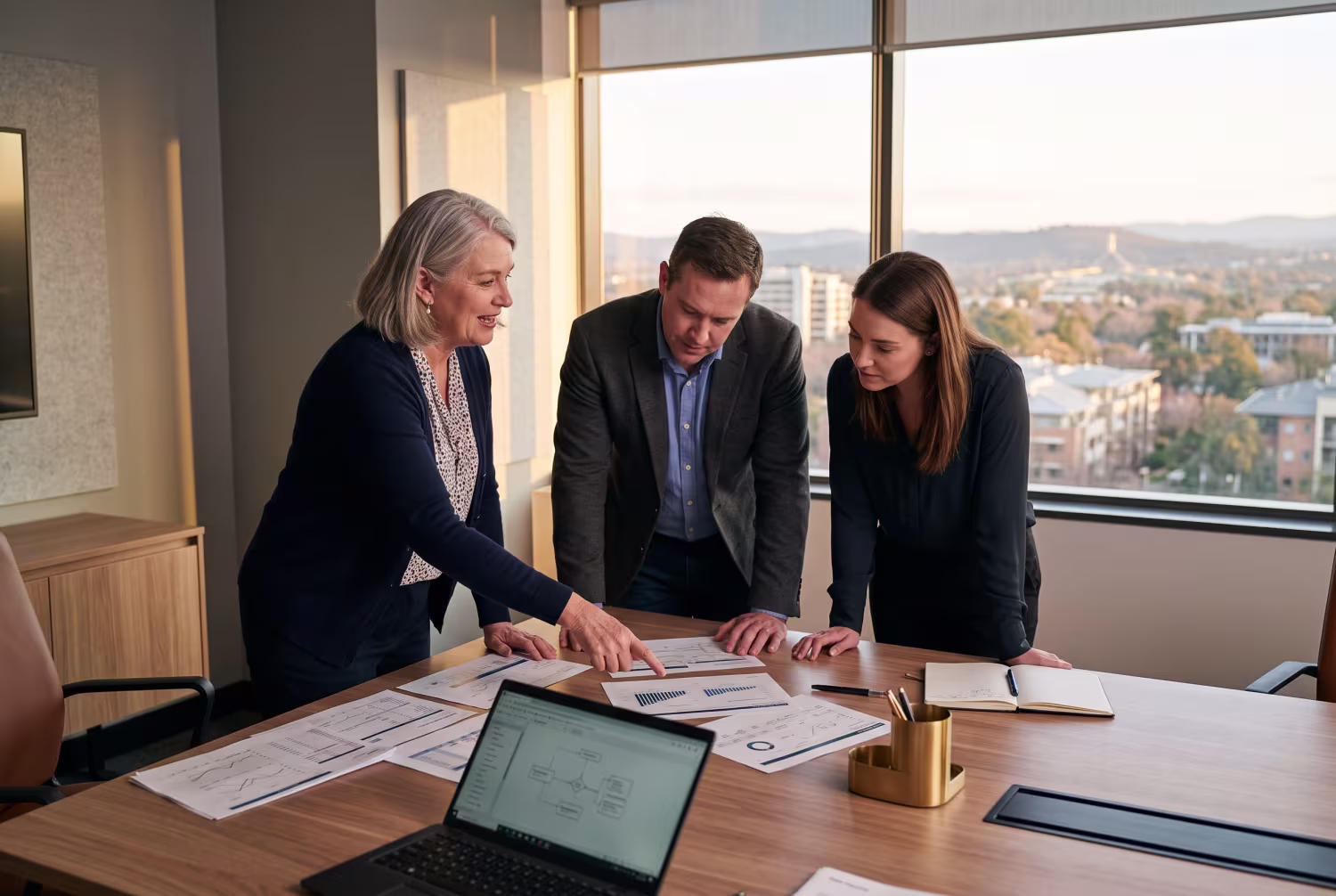 IT risk consultant discussing documents with business representatives in Canberra office