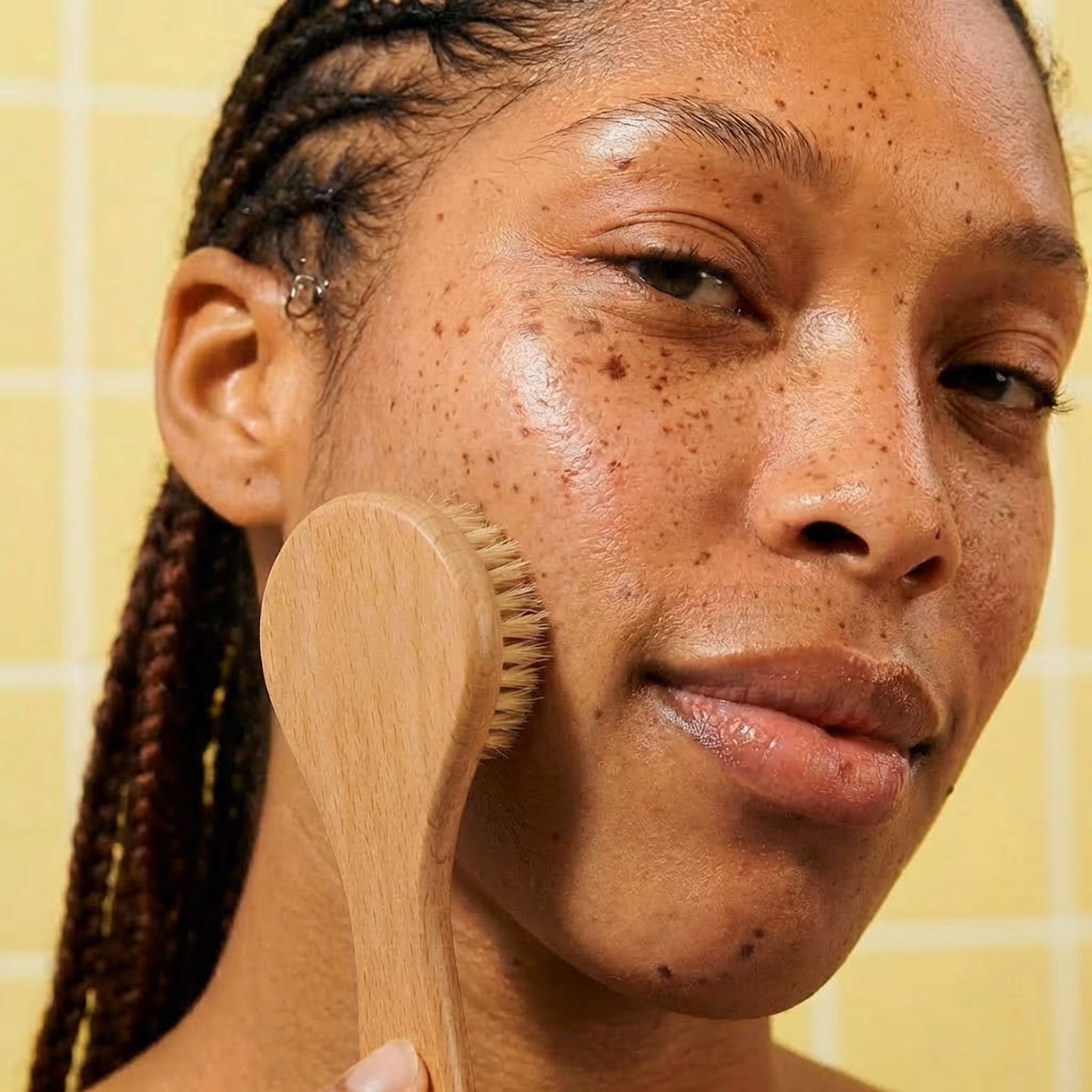 Facial dry brush used on cheek for gentle exfoliating skincare