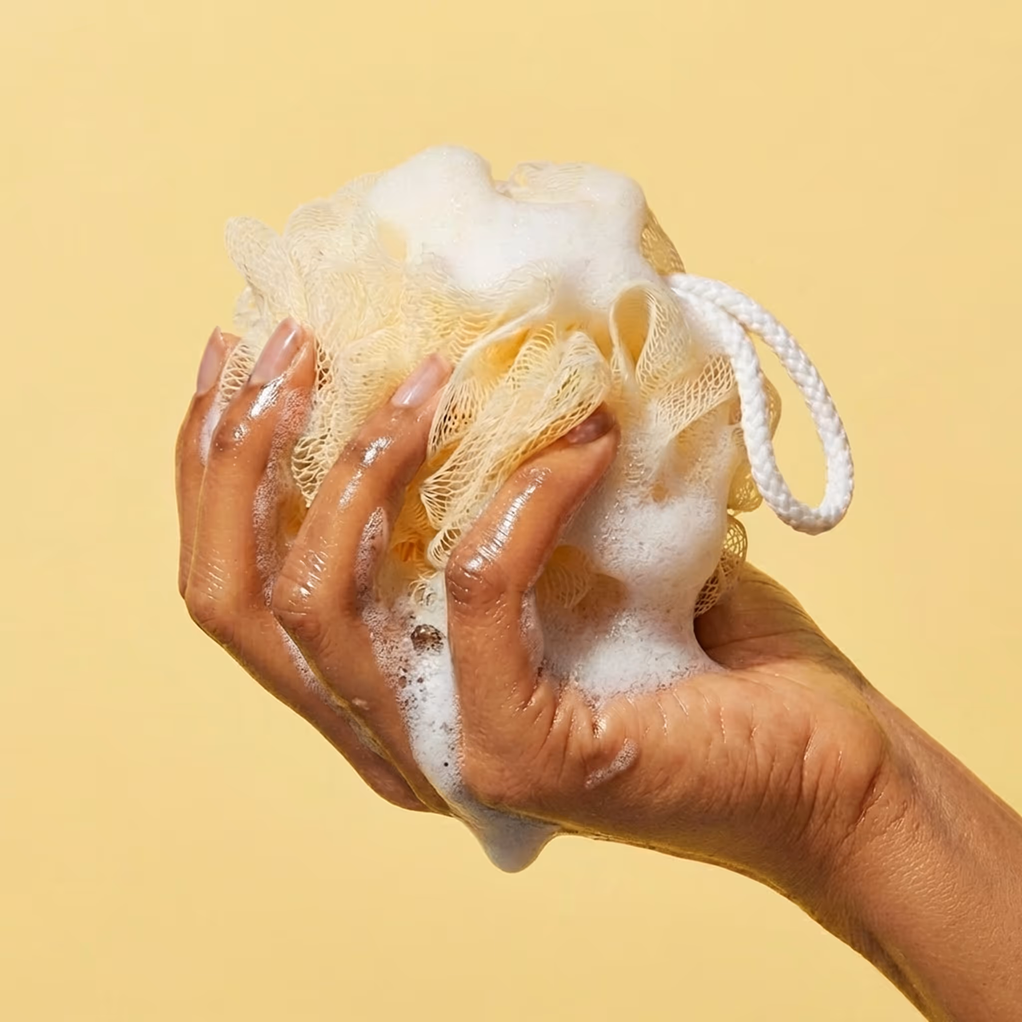 Compostable mesh sponge with foam held in hand close-up