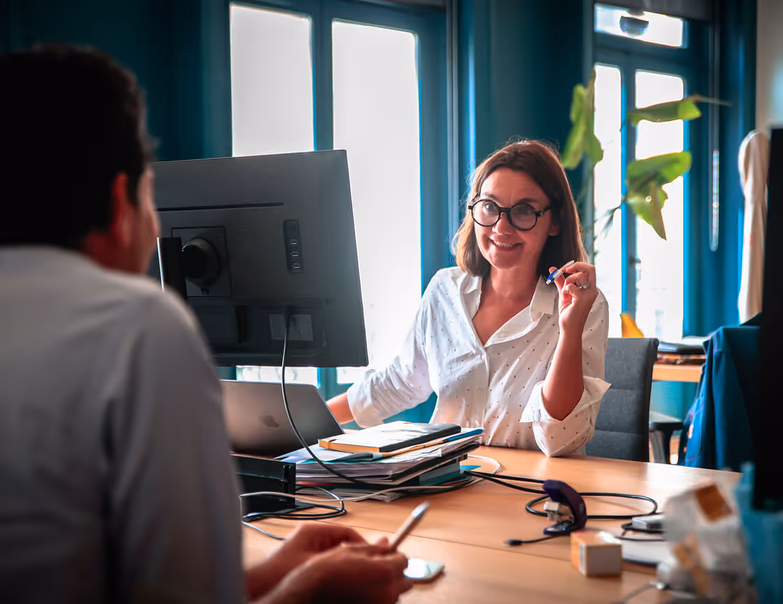 Une femme discutant avec un client devant son ordinateur