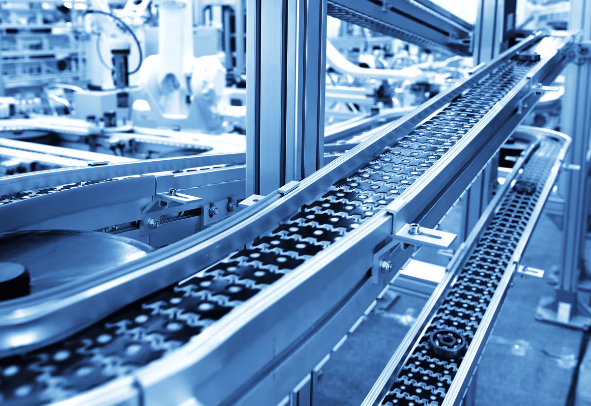 Empty metal conveyor belts inside a modern automated industrial factory.