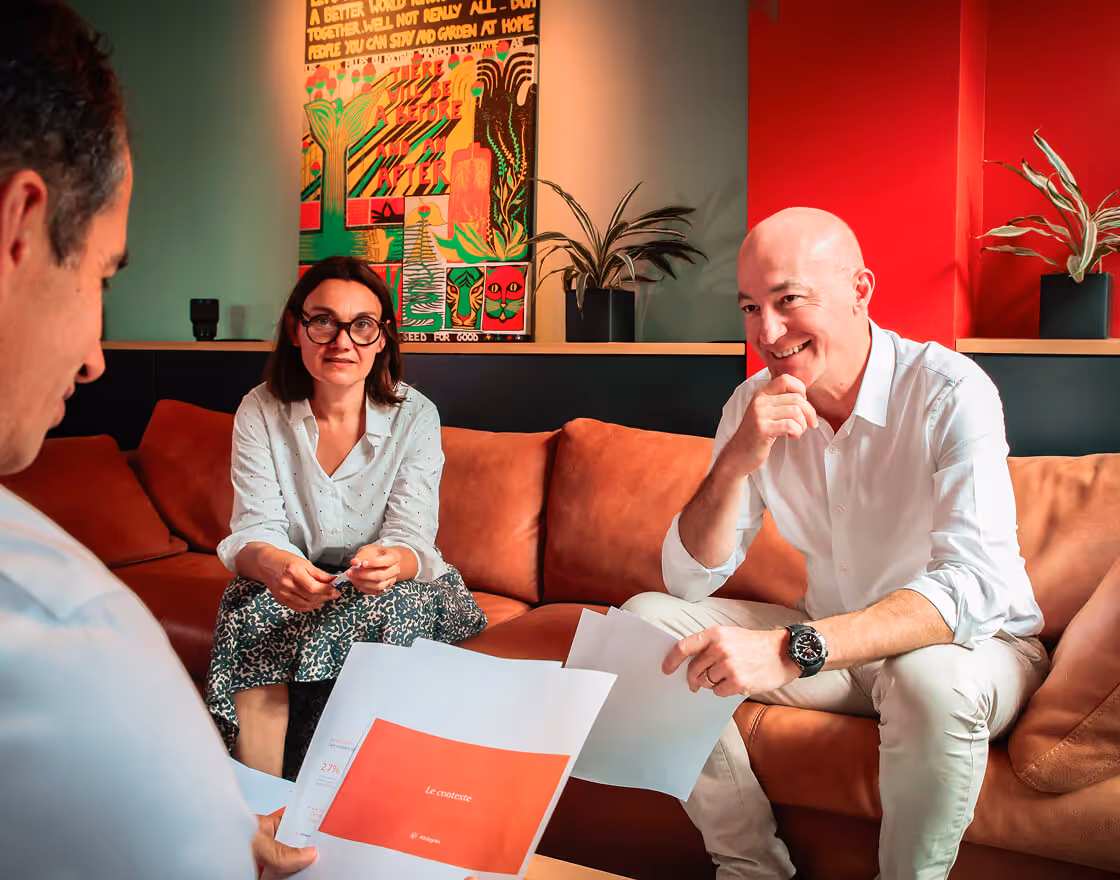 3 personnes discutant autour d'une table