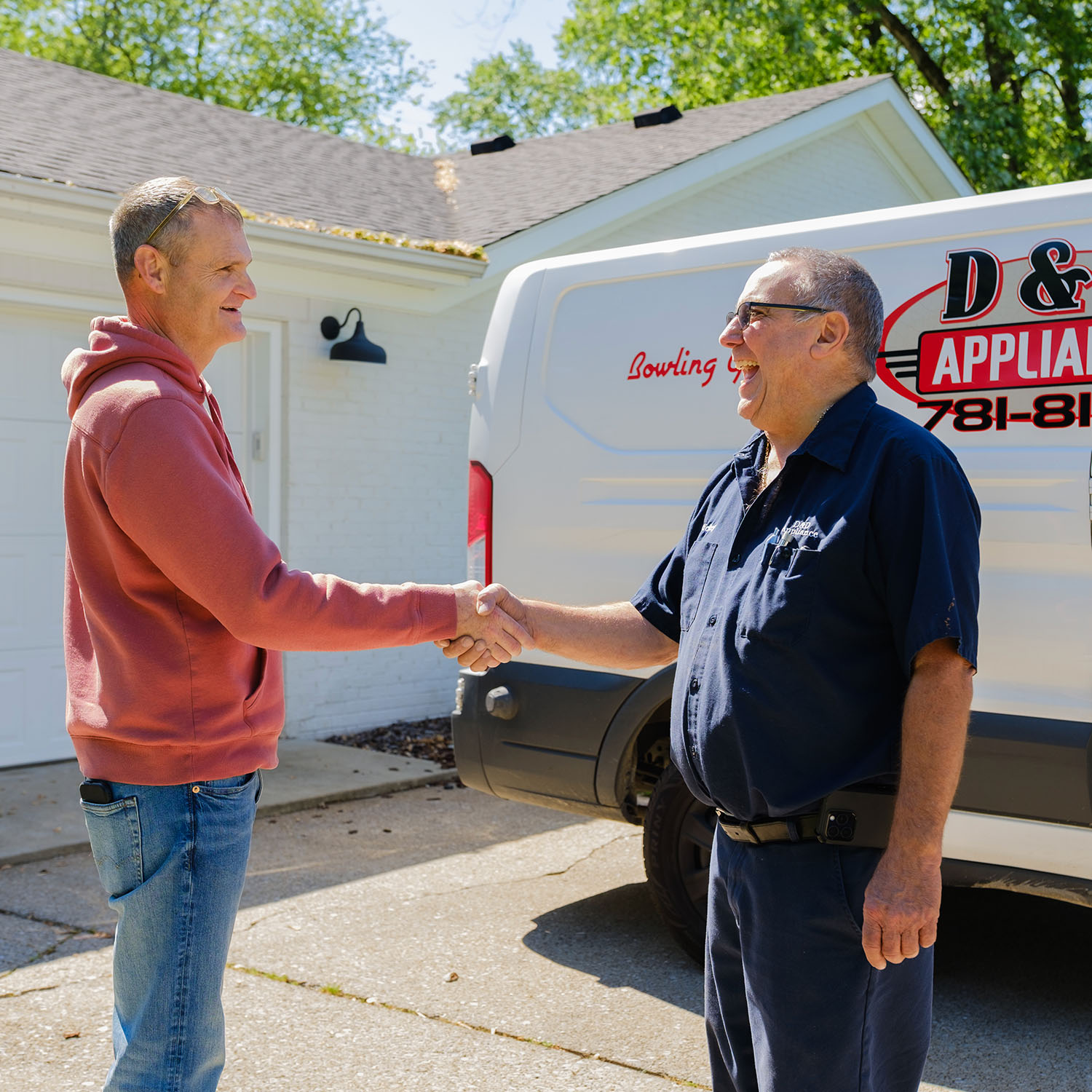 D&D Appliance technician shaking hands with a customer in front of the D&D service van in Bowling Green, KY, representing our installation and haul-away services
