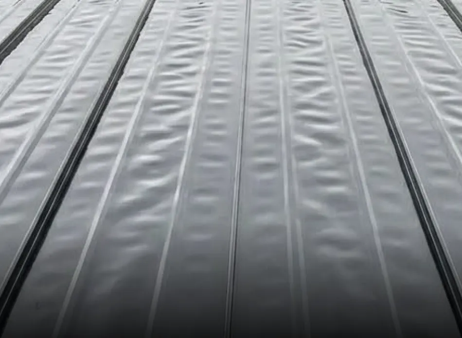 Close-up view of a wavy metal surface with parallel ridges.