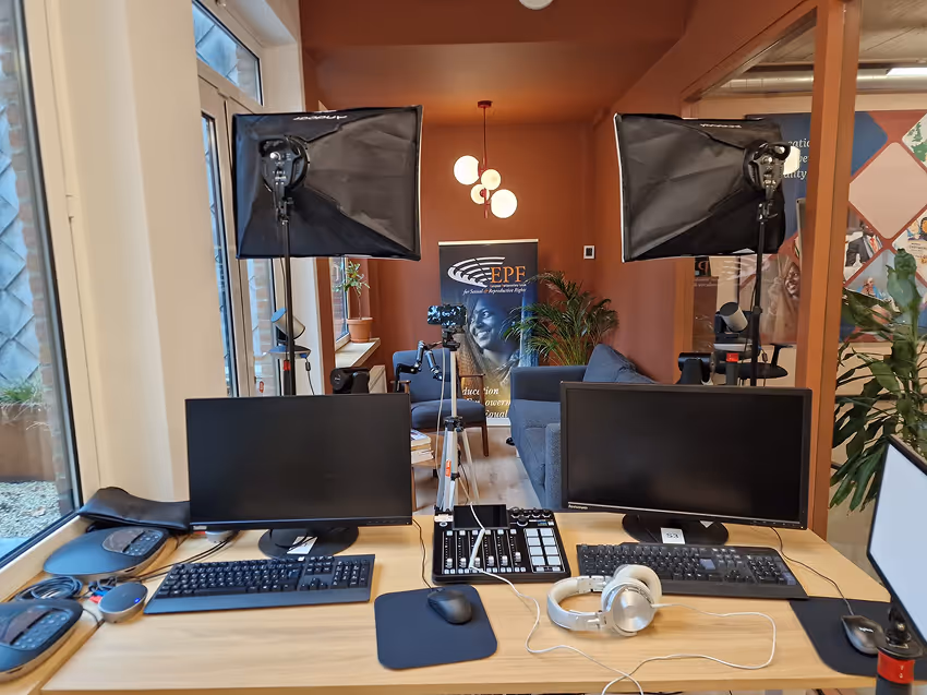 Empty modern wooden desk with a gray office chair and a gold adjustable desk lamp on a wooden slatted wall background.