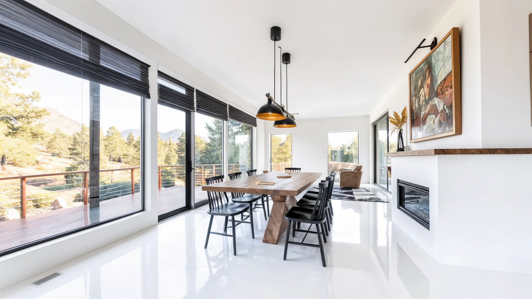 Bright dining room with white polished floors, large windows with tree views, rustic wood dining table, black chairs, black pendant lights, gas fireplace, and framed art