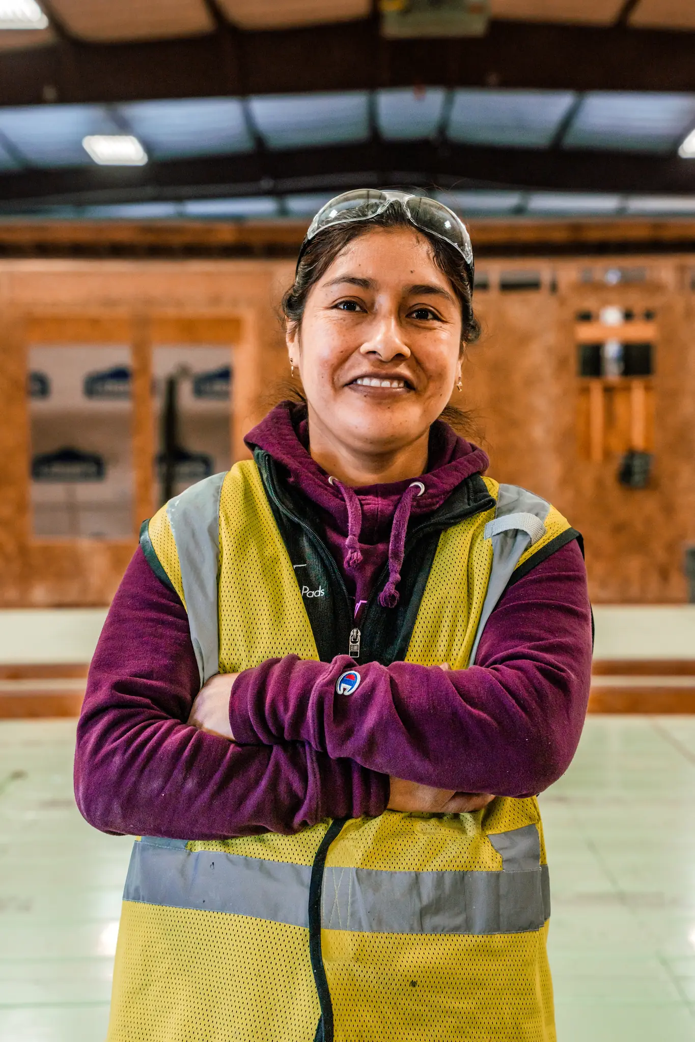 Smartpads team member in yellow safety vest and protective glasses smiling in the manufacturing plant