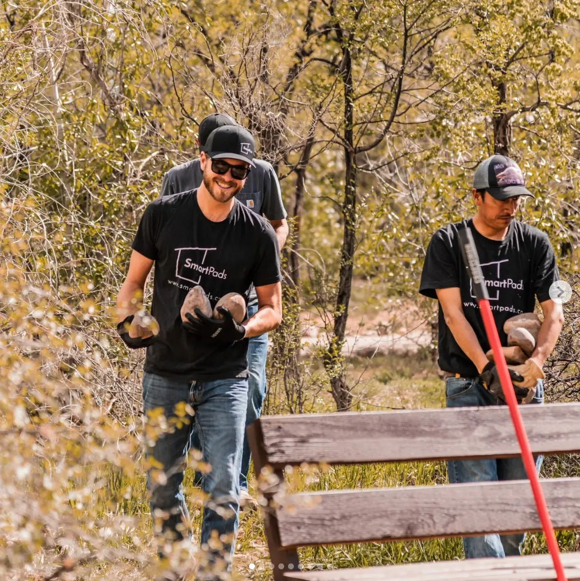 Smartpads team members in branded shirts doing community volunteer work outdoors