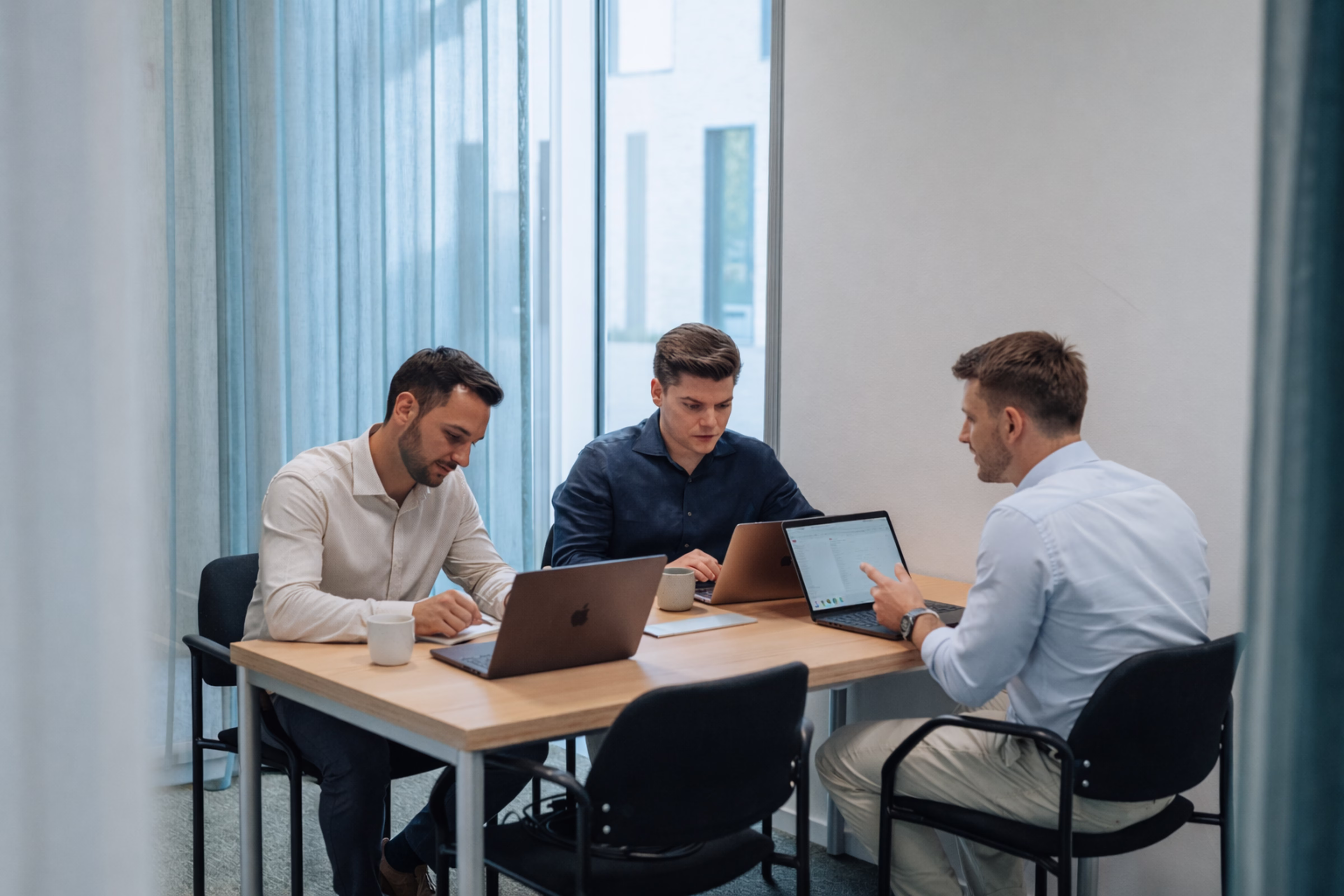 Drie Yggra-consultants werken geconcentreerd samen aan pricing-analyse