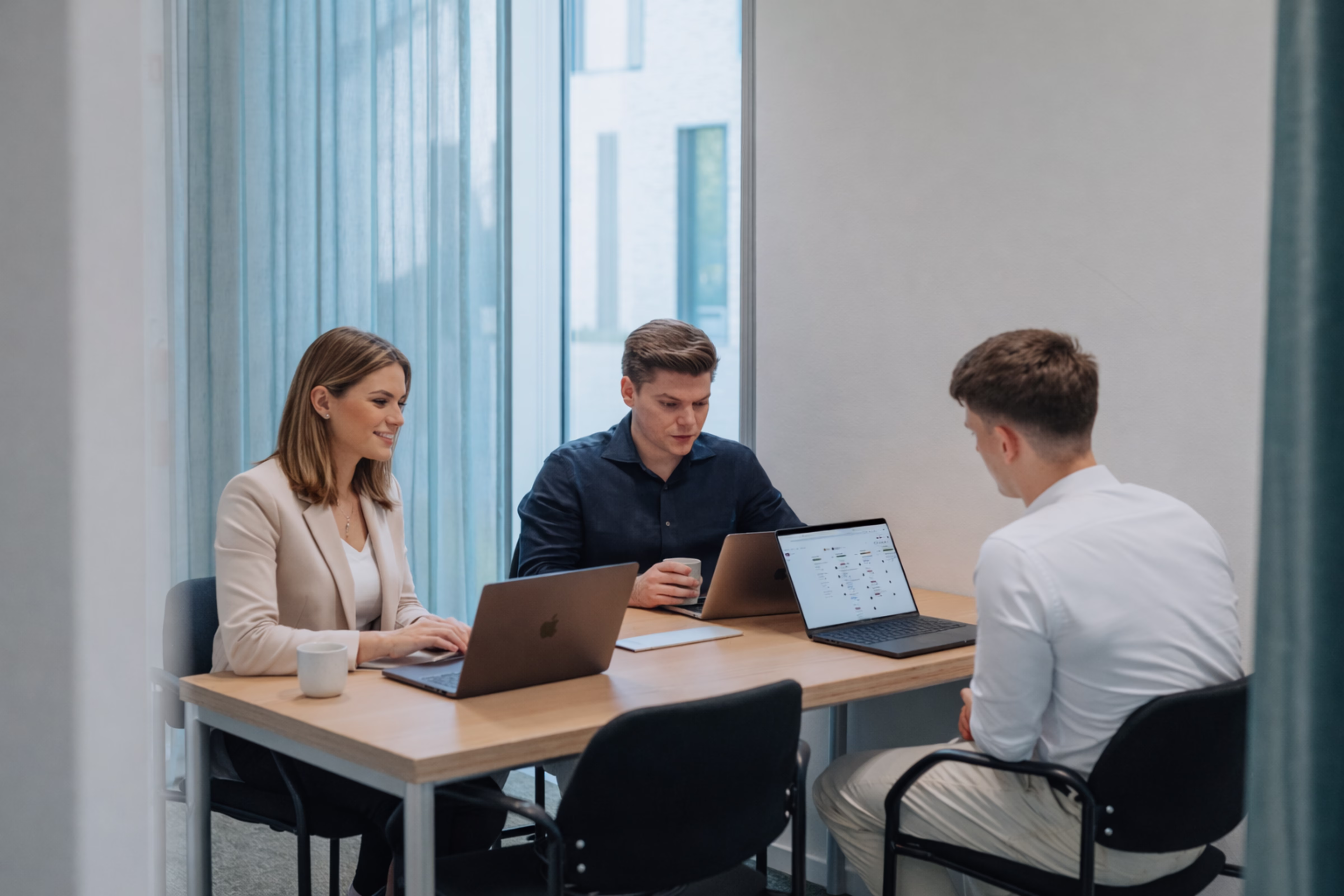 Yggra-consultant in gesprek met collega's aan een werktafel