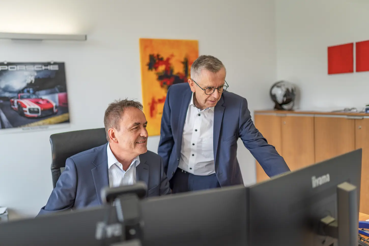 Zwei Partner von Schoetz & Partner bei der gemeinsamen Arbeit am Bildschirm in der Kanzlei in Göppingen.
