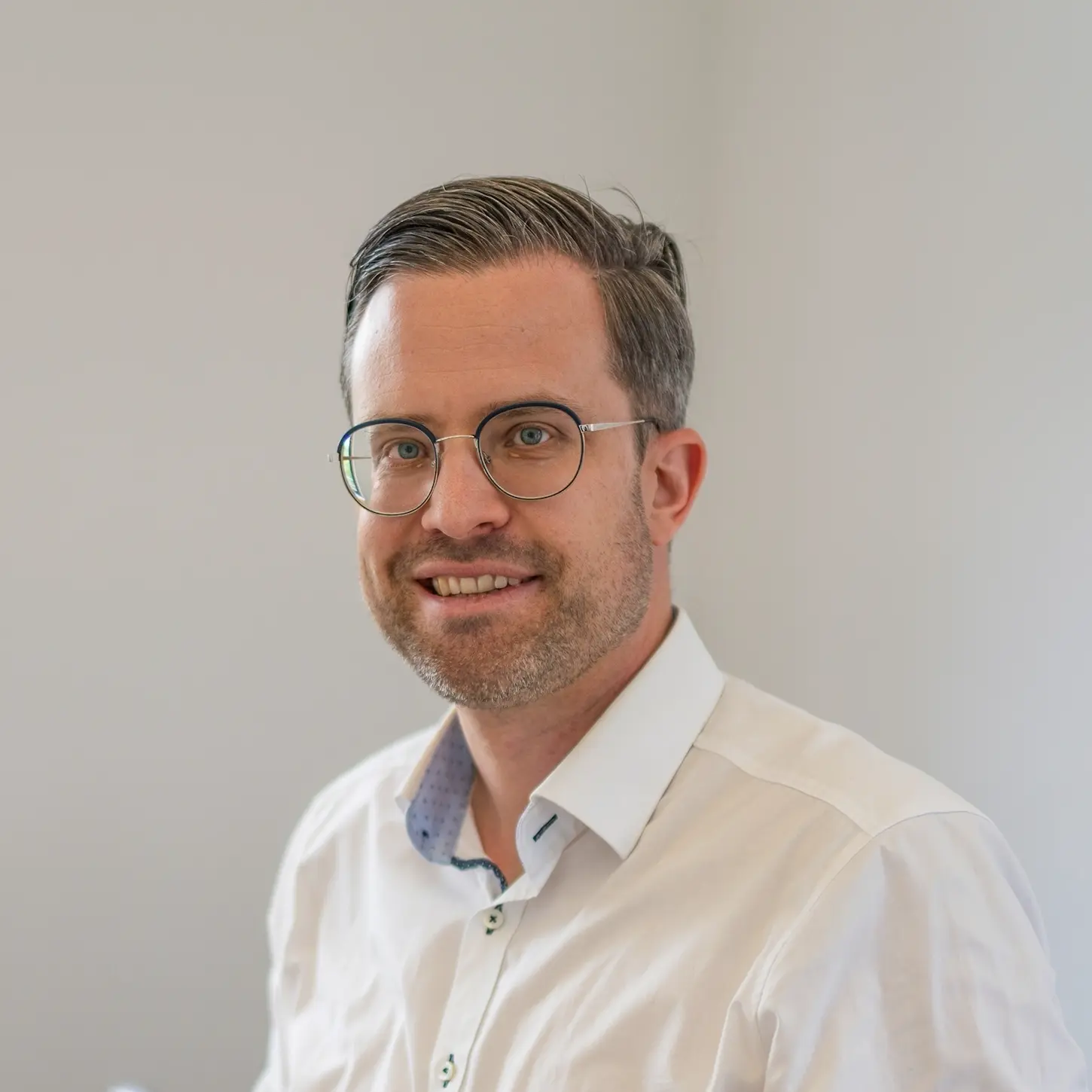 Portrait eines Mitarbeiters von schoetz-partner im Gespräch mit modernem Business-Look und heller Büroatmosphäre