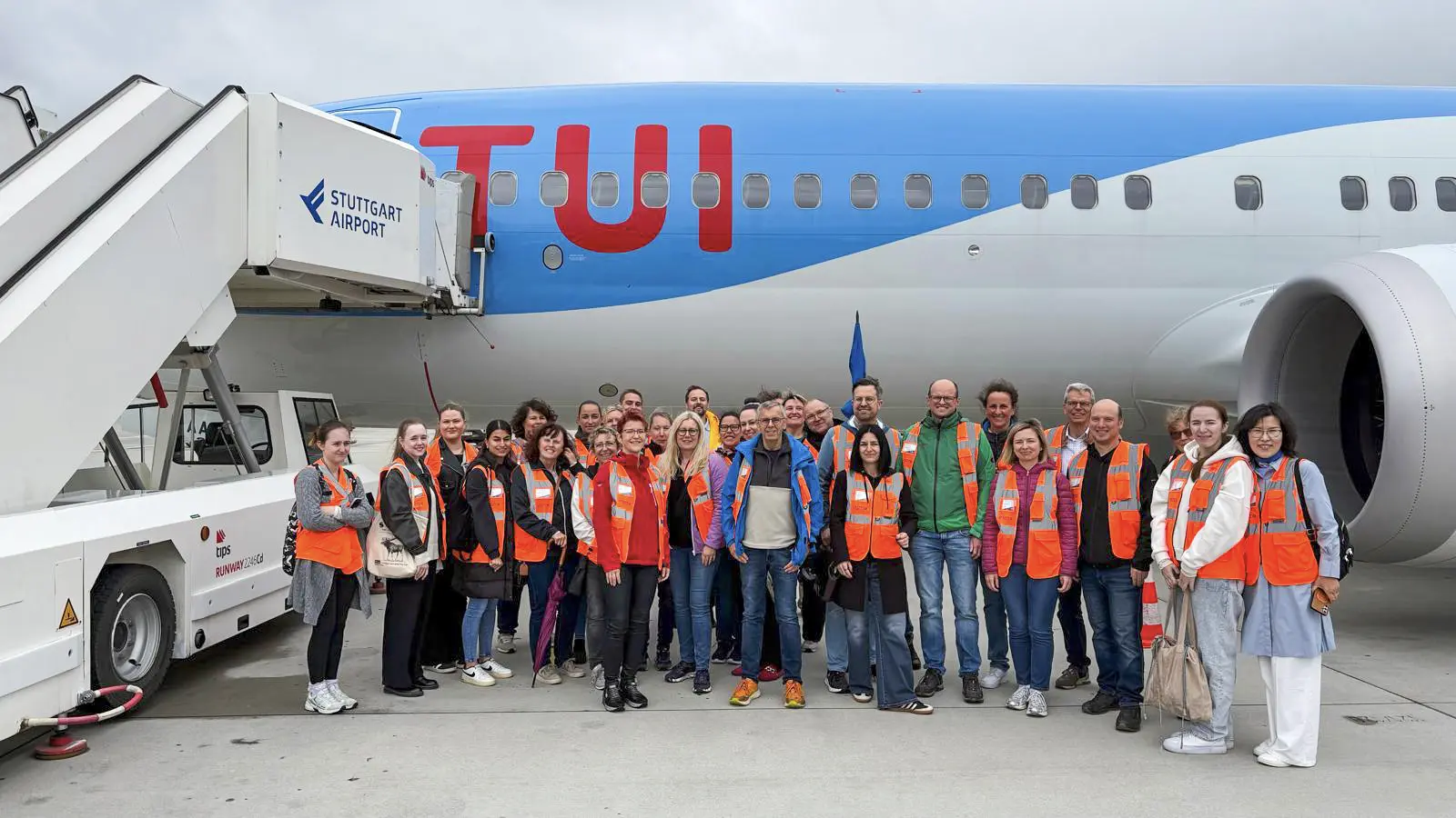 Team von Schoetz & Partner beim Betriebsausflug 2026 vor einem TUI-Flugzeug am Flughafen Stuttgart.