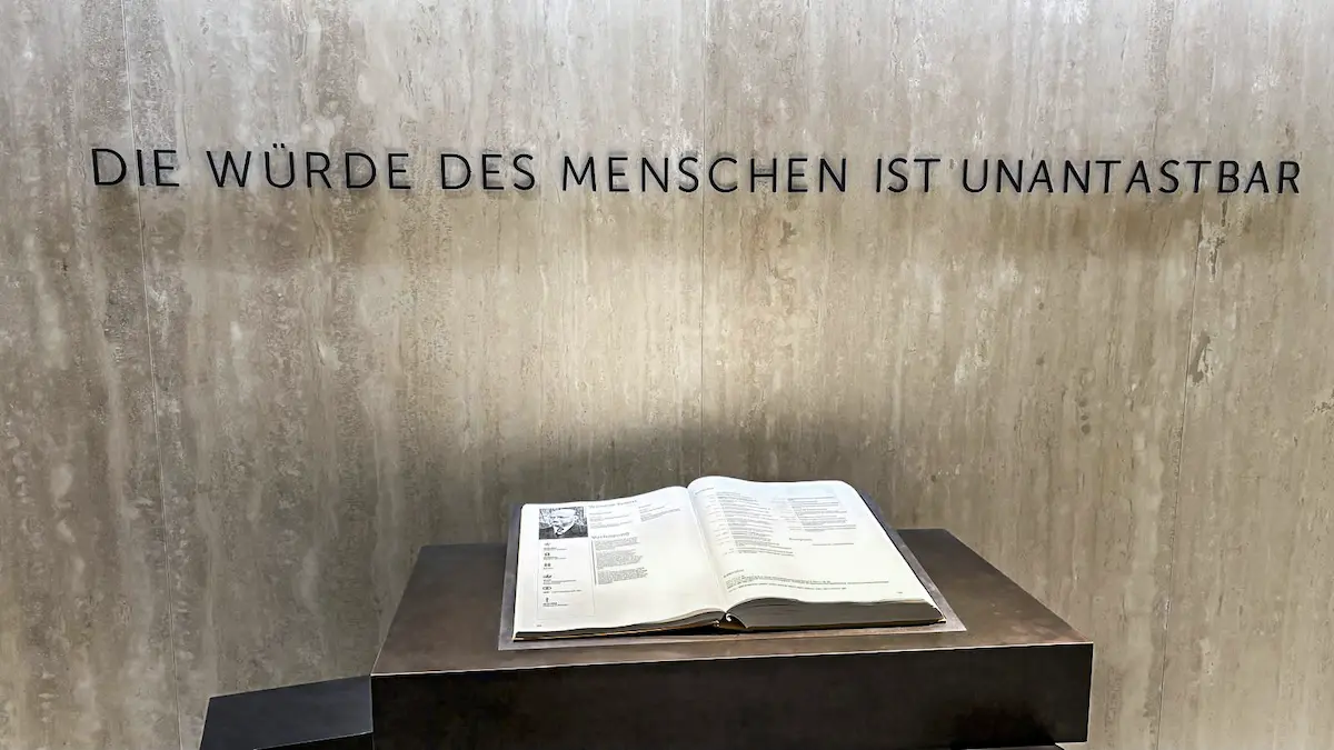 Ausstellung im Landtag von Baden-Württemberg mit dem Schriftzug „Die Würde des Menschen ist unantastbar“ und einem aufgeschlagenen Buch.