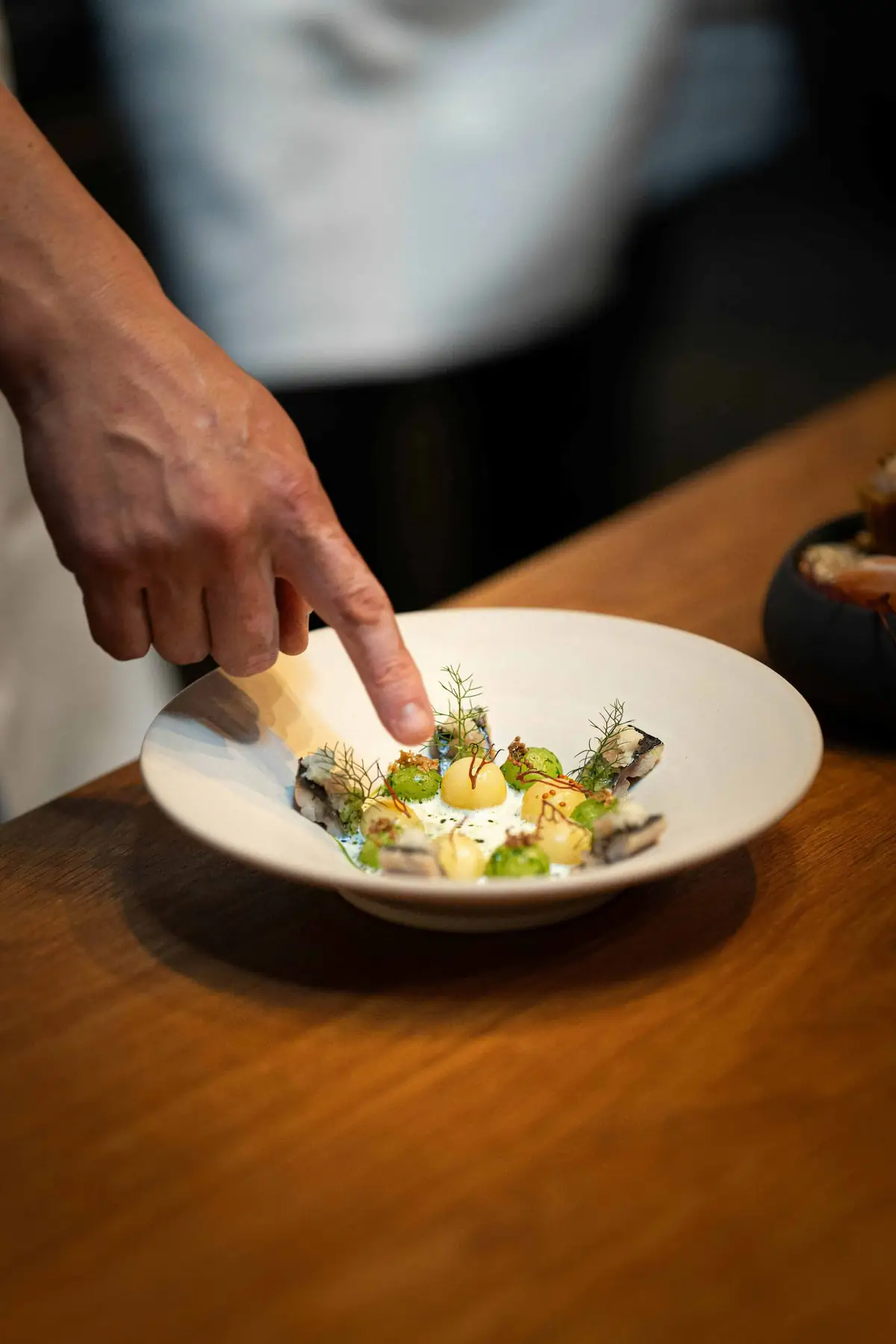 chef putting finishing touches on plate