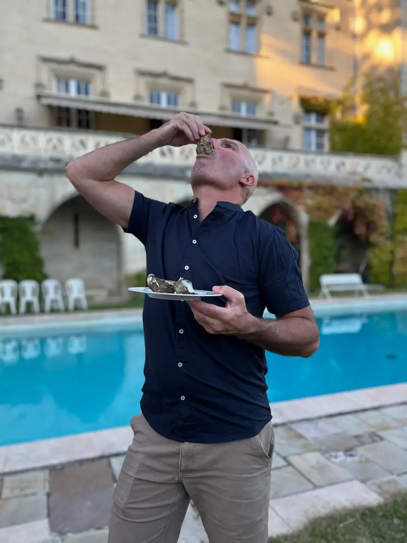 anthony eating a plate of oysters in french courtyard