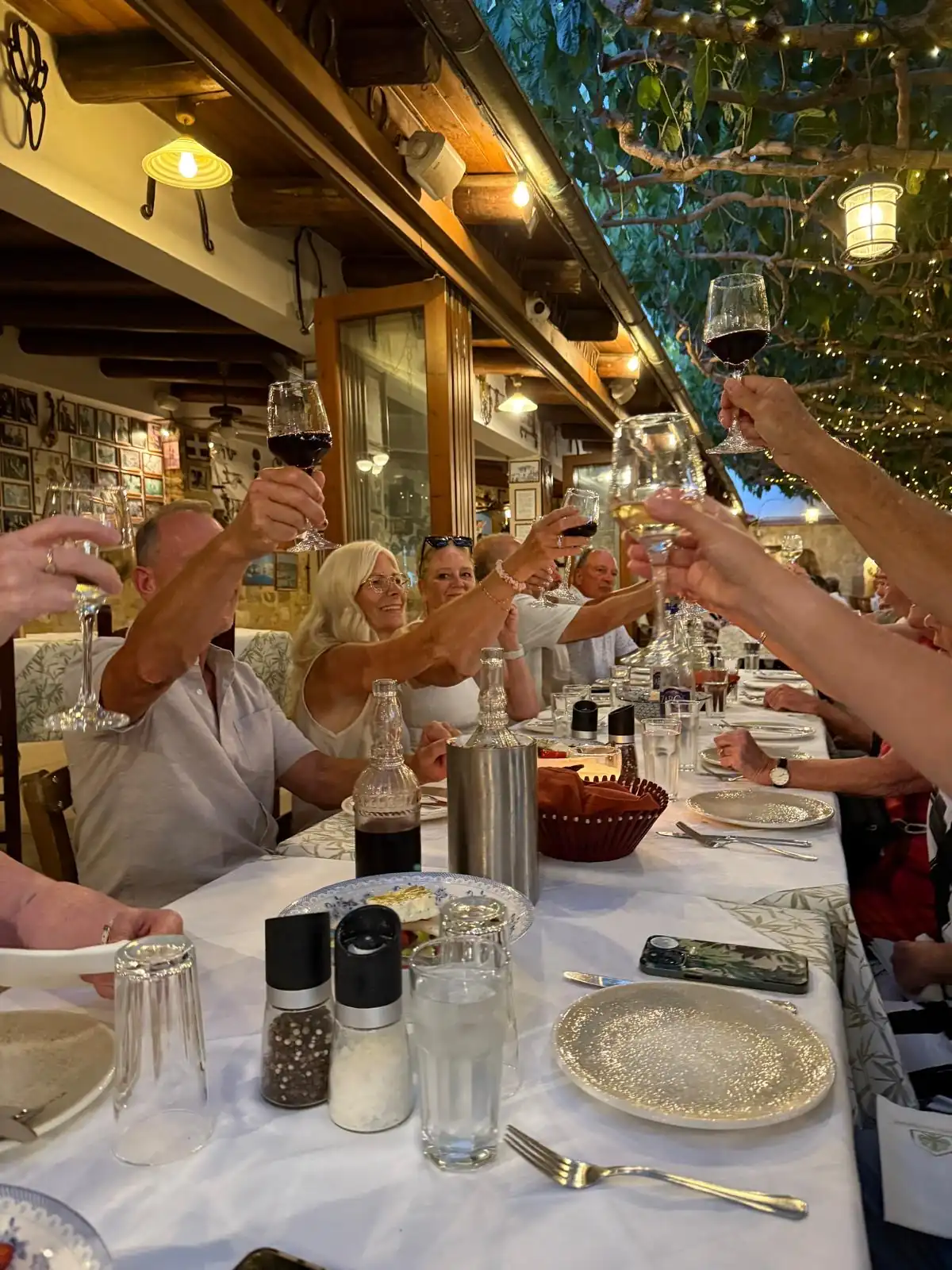 travellers toasting at long table for evening night out